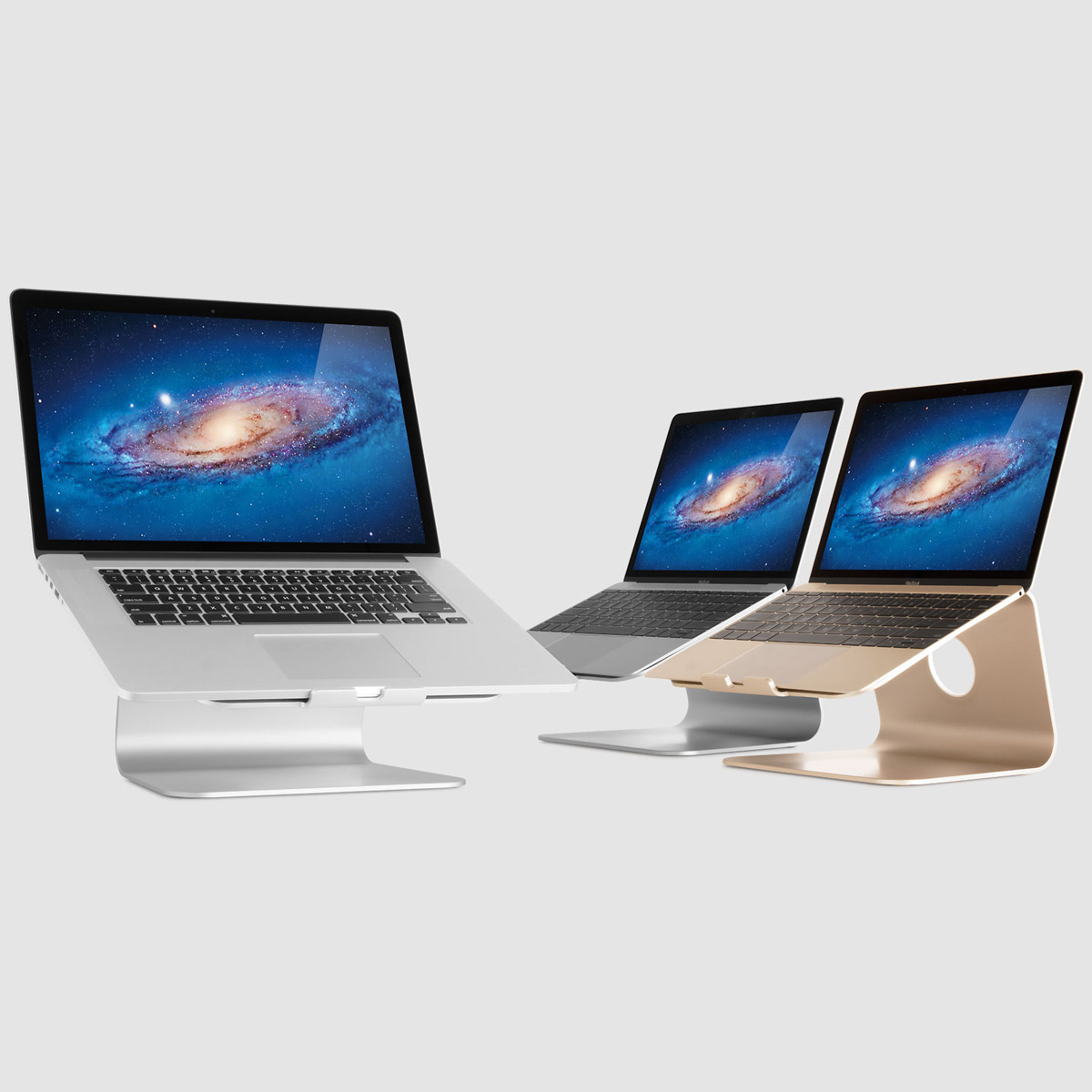 Three laptops on metal stands against a gray background display galaxy wallpaper.