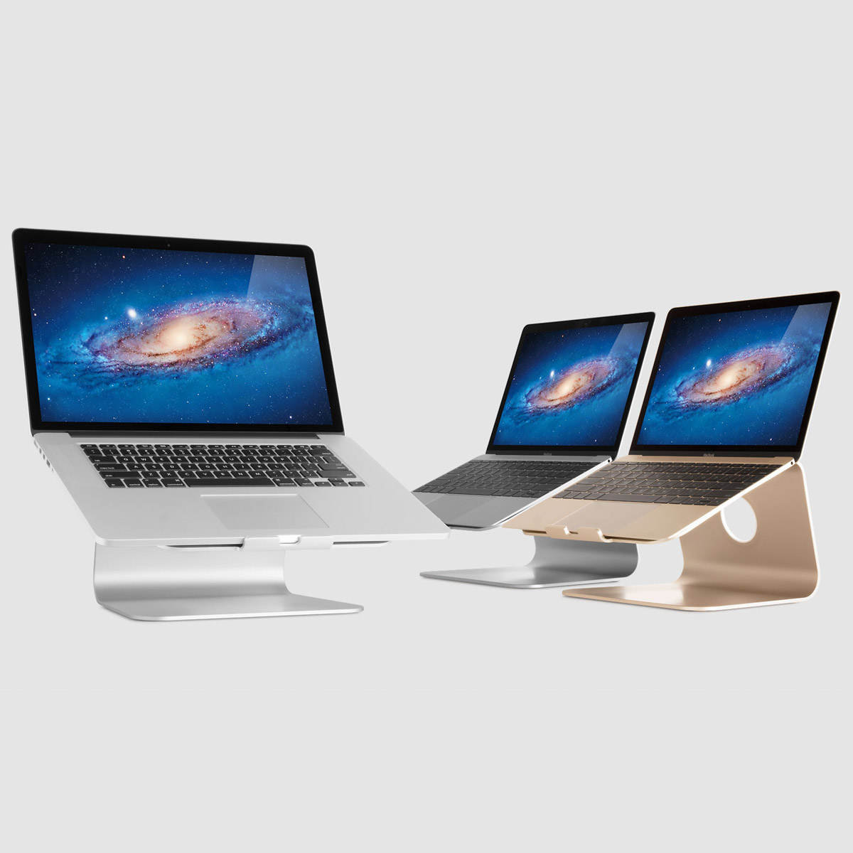 Three laptops on metal stands against a light gray background, all displaying a galaxy wallpaper.