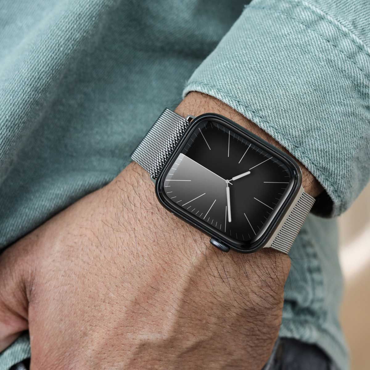 Nahaufnahme einer Person, die eine Smartwatch mit Metallarmband und schwarzem Zifferblatt trägt.
