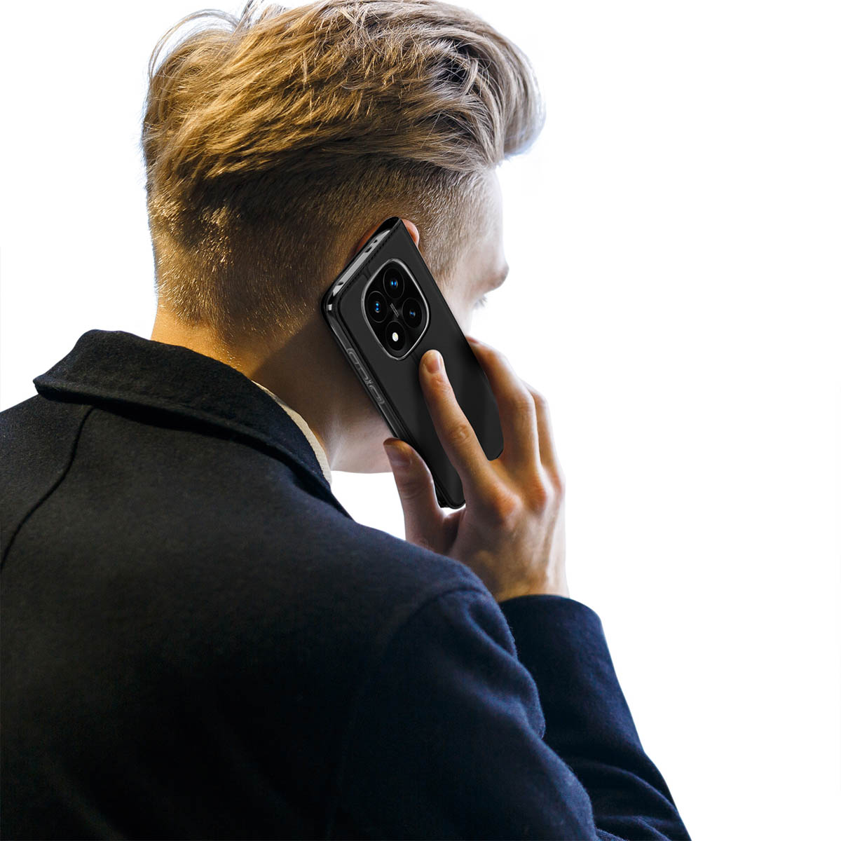 Ein blondhaariger Mann in einem dunklen Mantel telefoniert mit einem schwarzen Smartphone auf weißem Hintergrund.