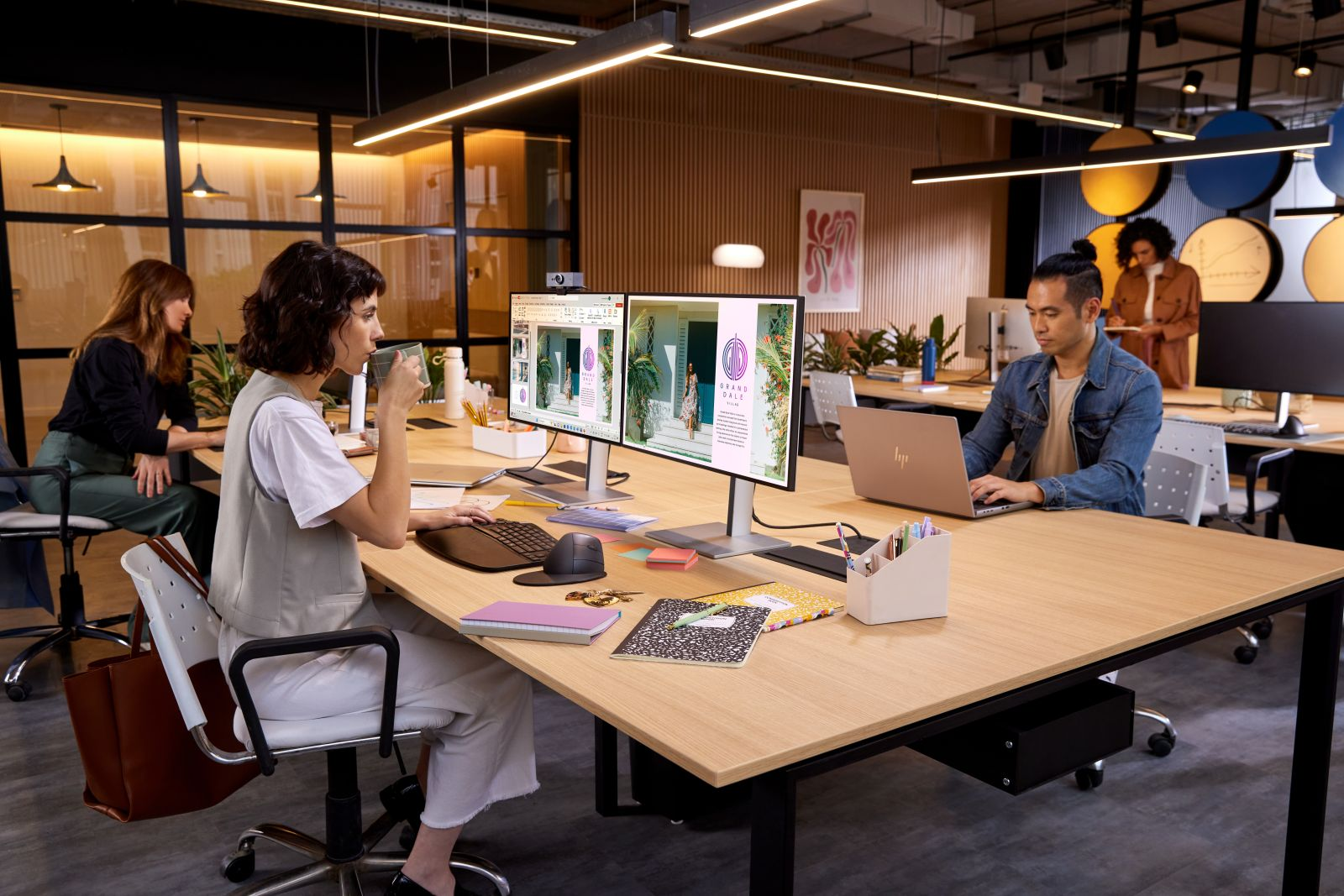 Moderne postazioni di lavoro con dipendenti al computer in un ufficio open space ben illuminato.