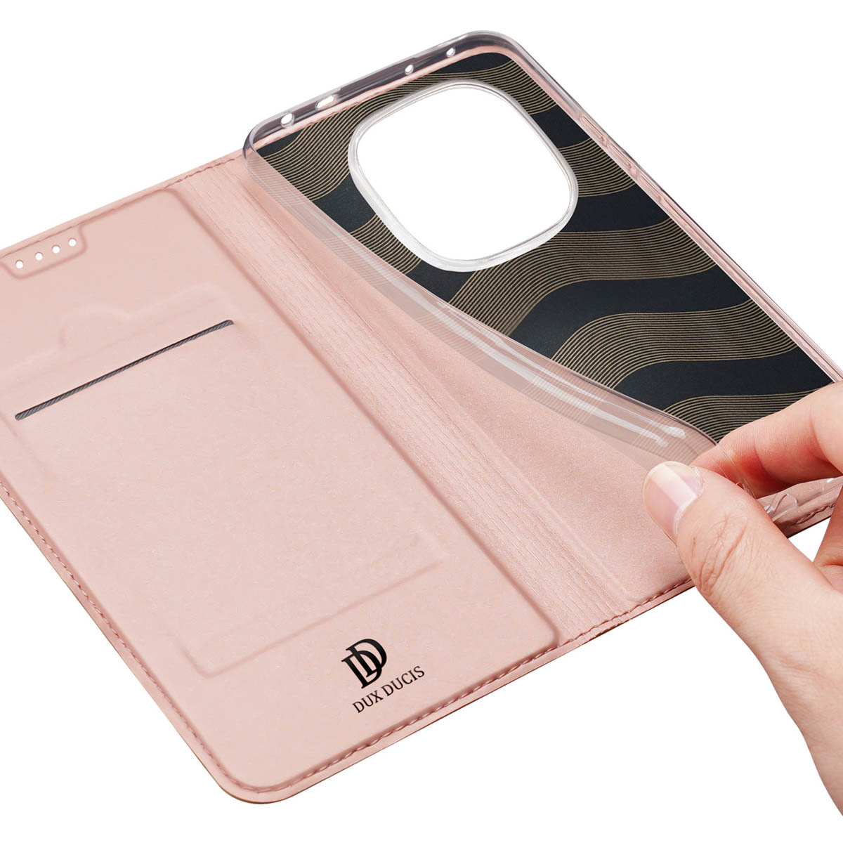 Eine Hand hebt eine transparente Handyhülle mit schwarz-goldenen Wellenlinien von einer rosa Ledertasche.