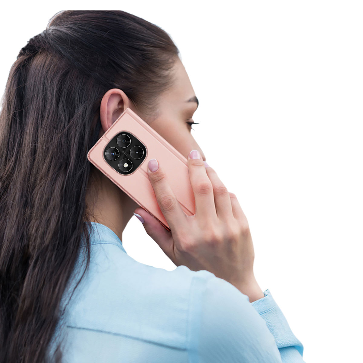 Eine Frau mit dunklen Haaren in einem hellblauen Hemd telefoniert mit einem rosafarbenen Smartphone.