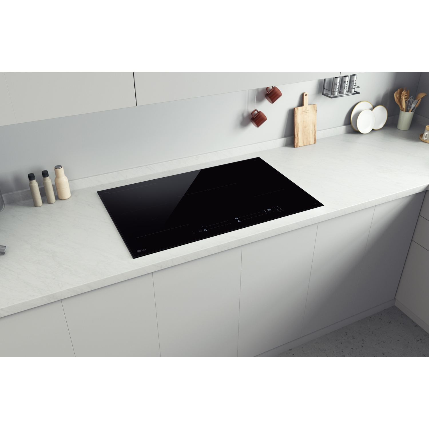 Un piano cottura a induzione nero è incassato in un piano di lavoro chiaro.