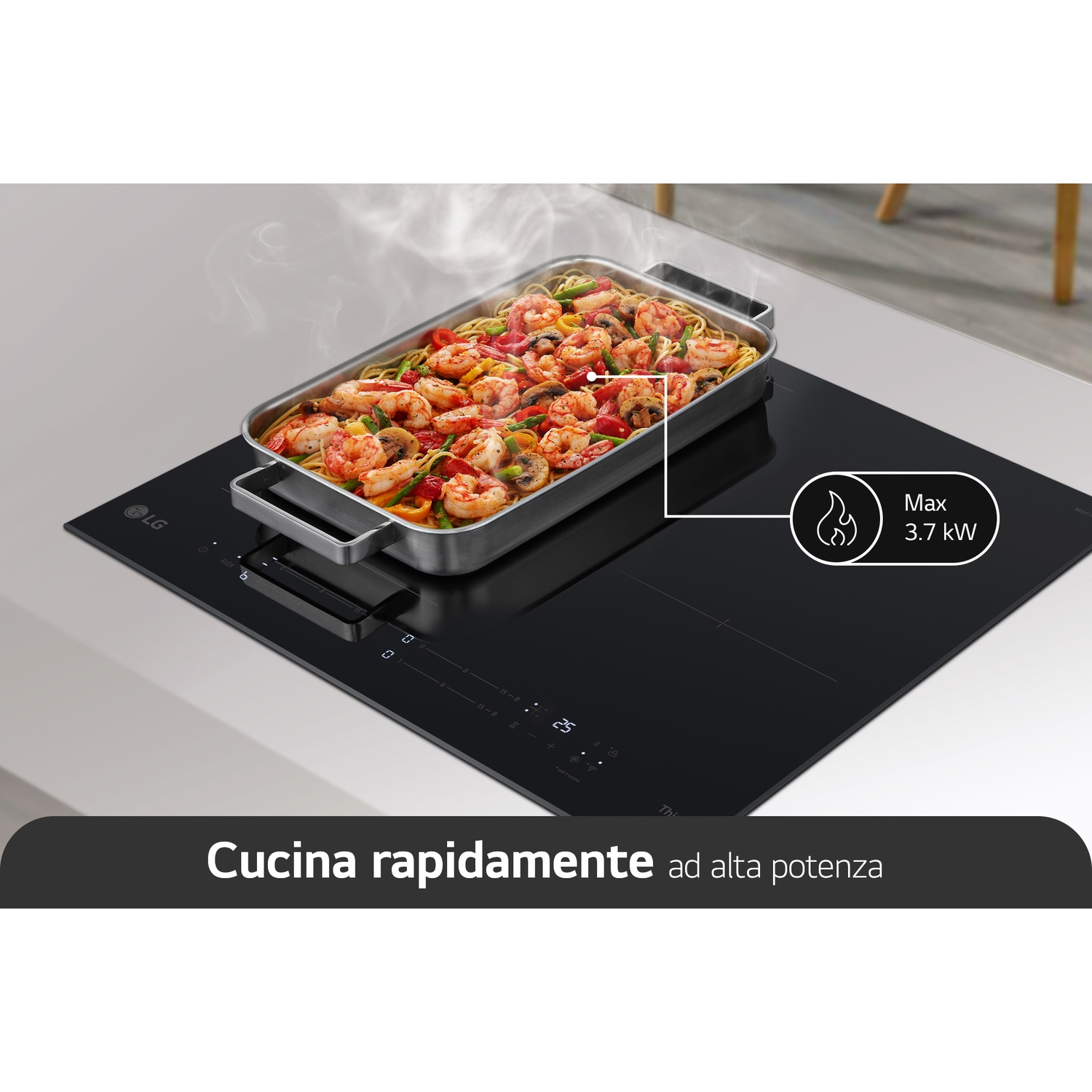 Una padella rettangolare di pasta fumante e gamberi cuoce su un piano cottura a induzione nero.
