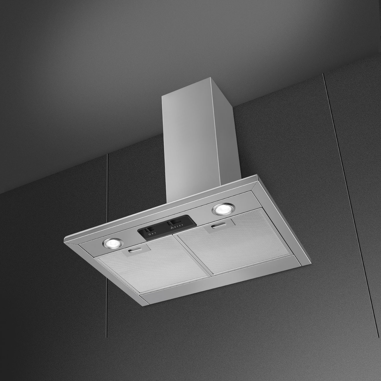 Una campana extractora plateada con dos luces y filtros de malla en una pared de cocina oscura.