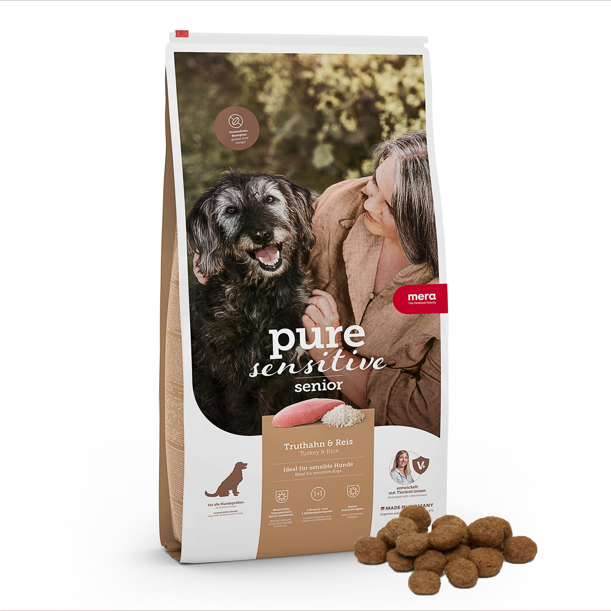 Eine Packung Mera Pure Sensitive Senior Hundefutter mit Truthahn und Reis, daneben einige Krokketen.