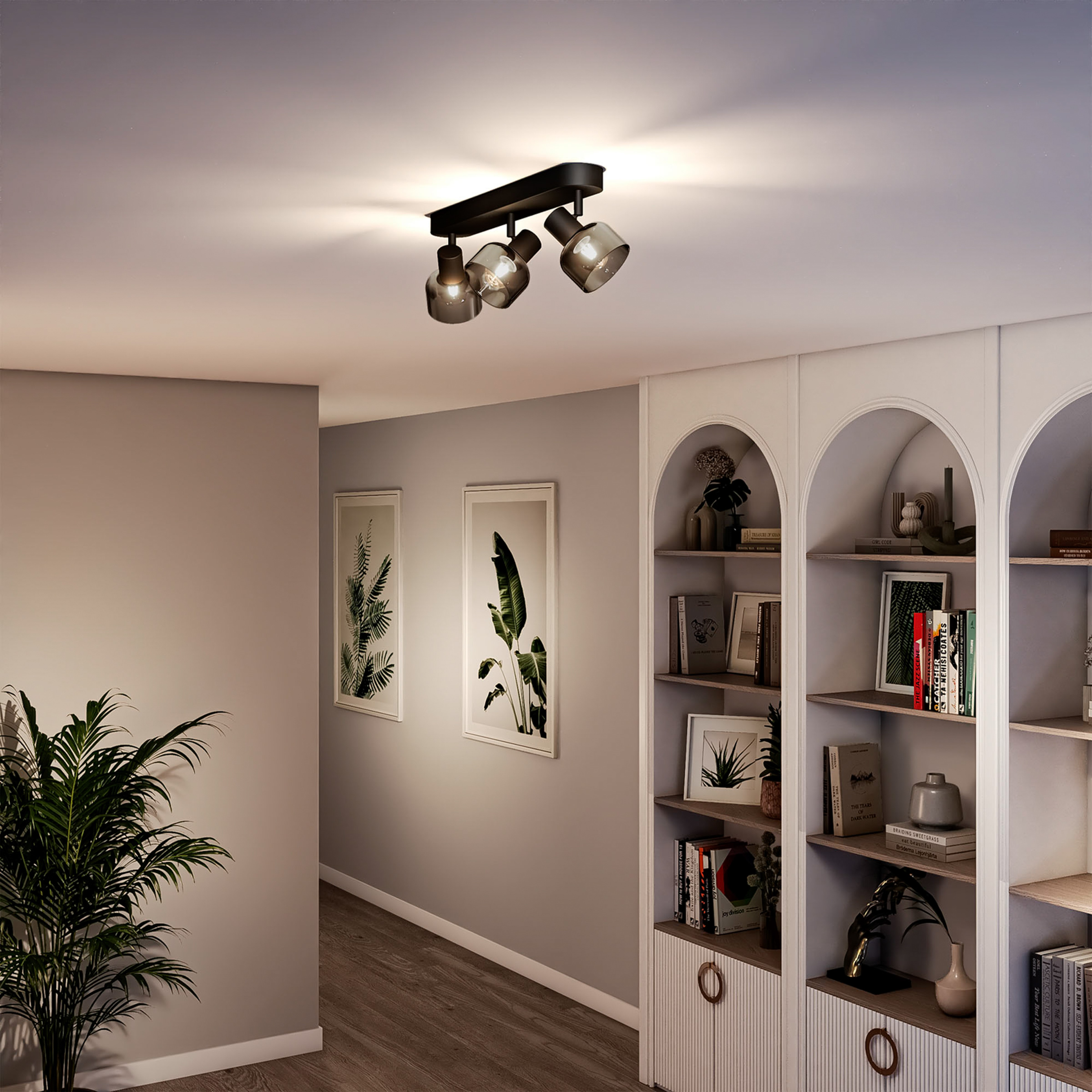 Moderne Deckenleuchte mit drei Spots in einem Flur mit Bildern und Regalen.