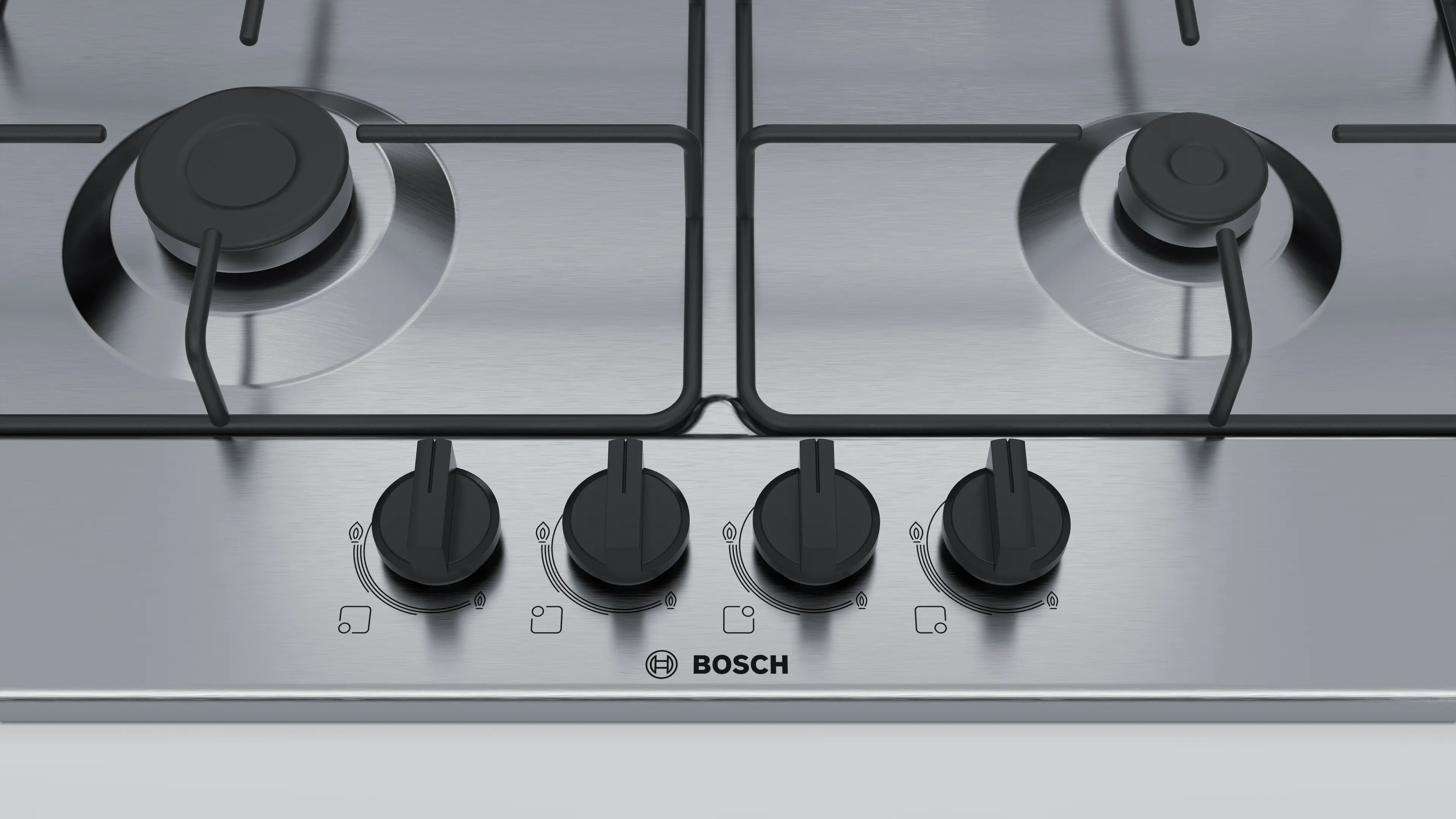 Placa de gas de acero inoxidable Bosch con cuatro mandos y quemadores negros.