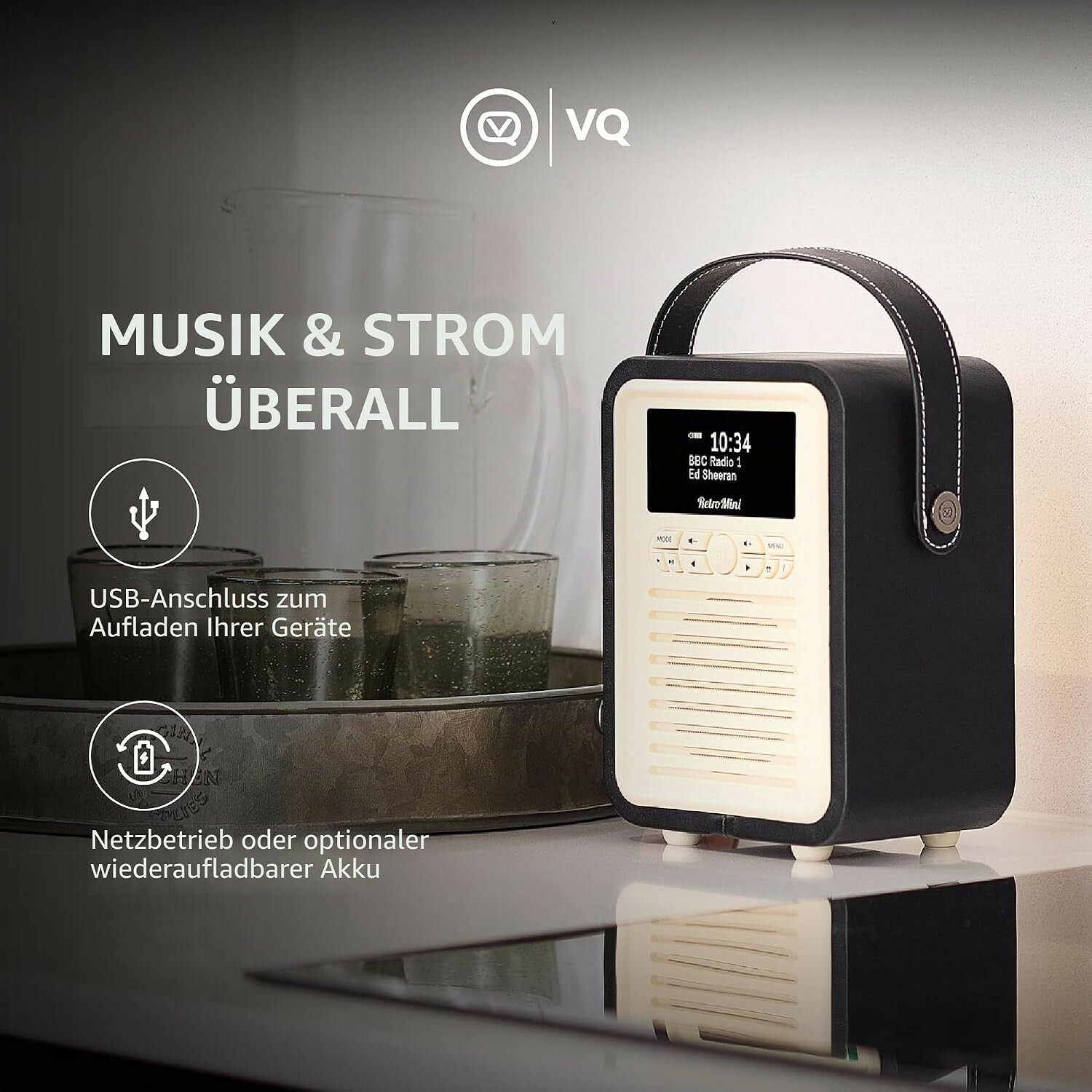 Ein schwarzes Retro-Radio mit Tragegriff auf einer Küchenoberfläche neben Gläsern und Text.