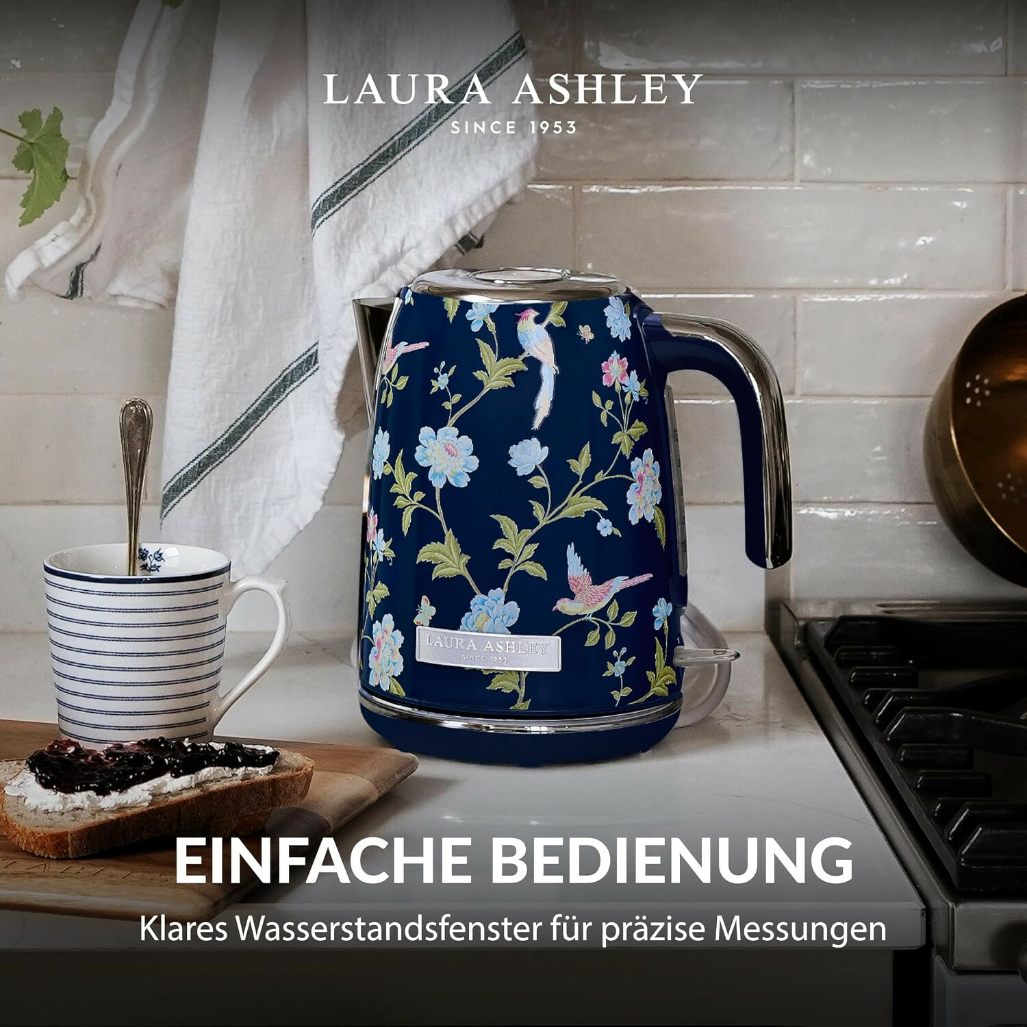 Blauer Laura Ashley Wasserkocher mit Blumenmuster auf Küchenarbeitsplatte, daneben Toast und gestreifte Tasse.