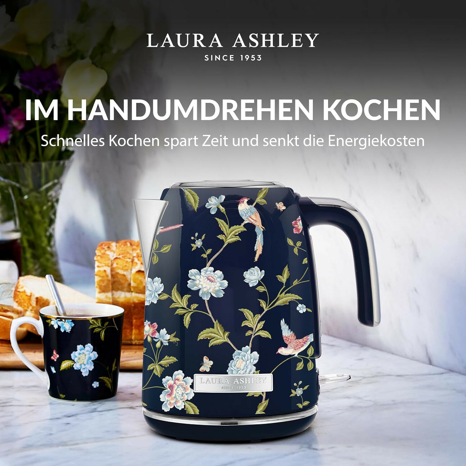 Dunkelblauer Laura Ashley Wasserkocher mit Blumen- und Vogelmuster auf einer Marmorarbeitsplatte.
