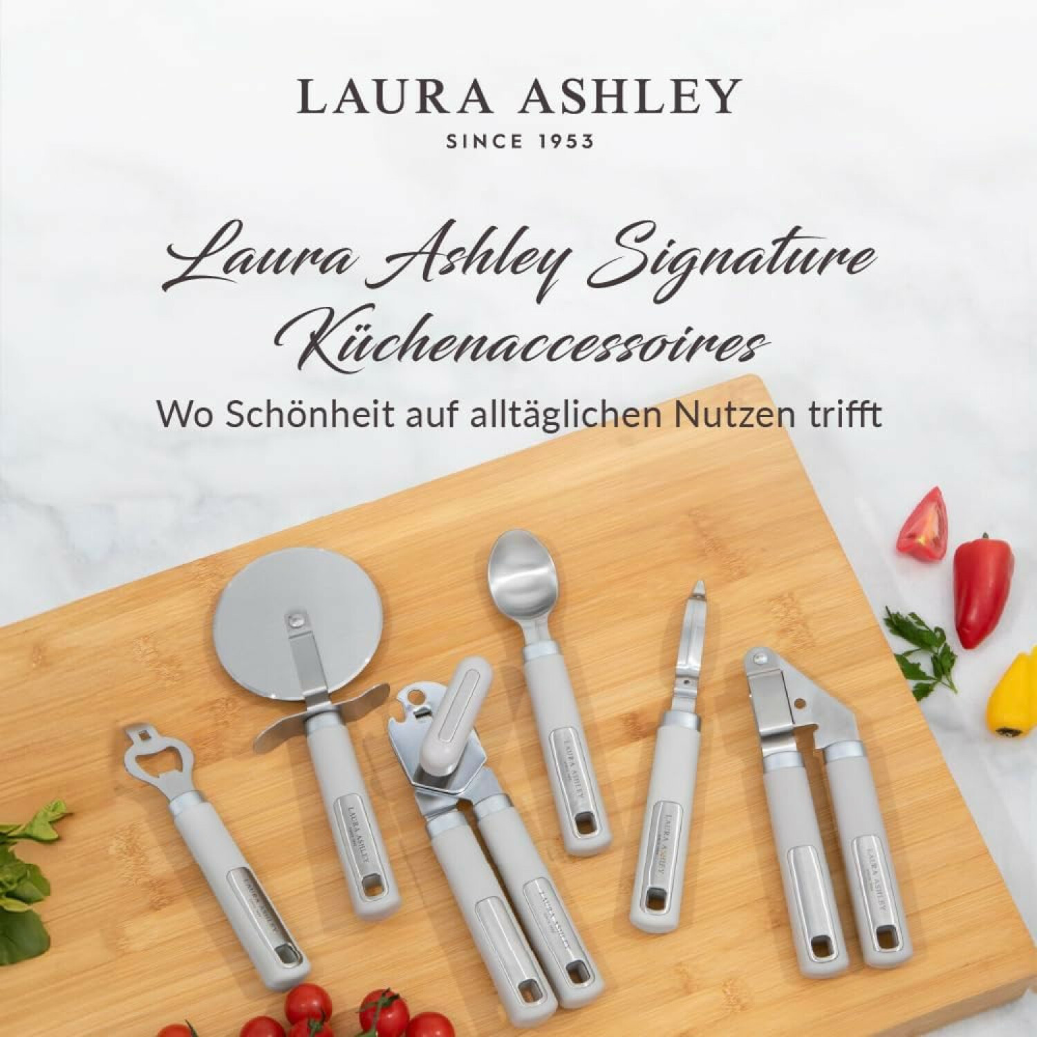 Laura Ashley Küchenaccessoires auf einem Holzbrett mit Gemüse und Text.