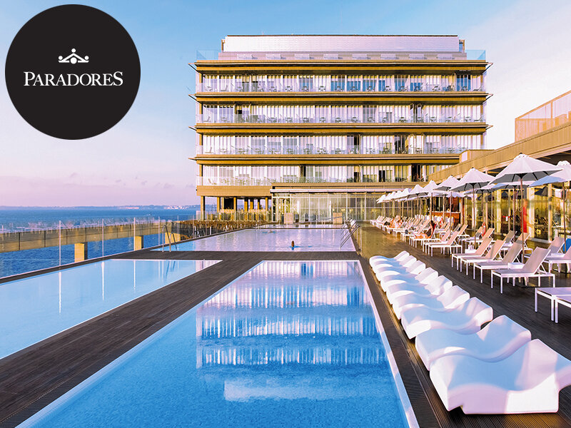 Hotel lujoso con piscinas infinitas, tumbonas y sombrillas con vista al mar al atardecer.
