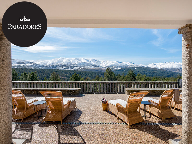 Tumbonas en una terraza con vistas a montañas nevadas y bosques verdes.