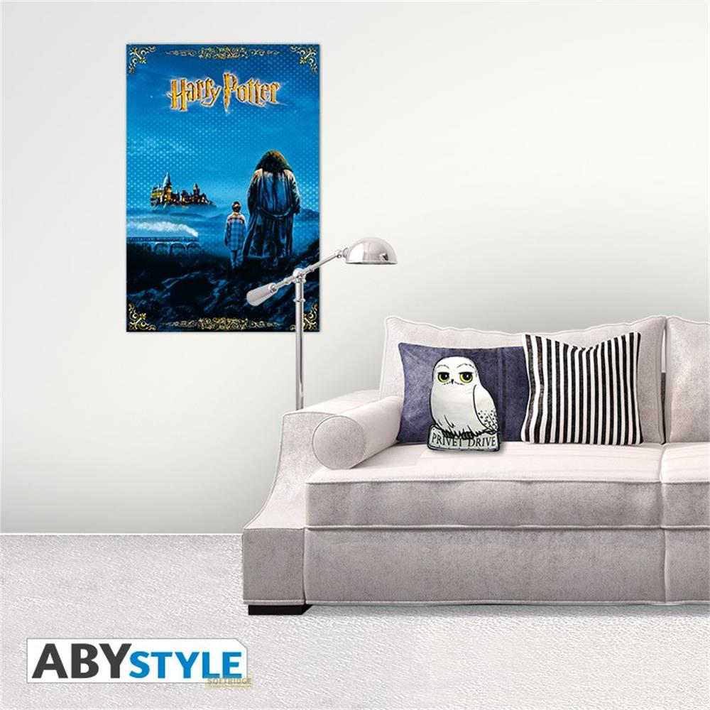 Ein weißes Sofa steht in einem hellen Raum neben einer Stehlampe, an der Wand hängt ein Harry-Potter-Poster.
