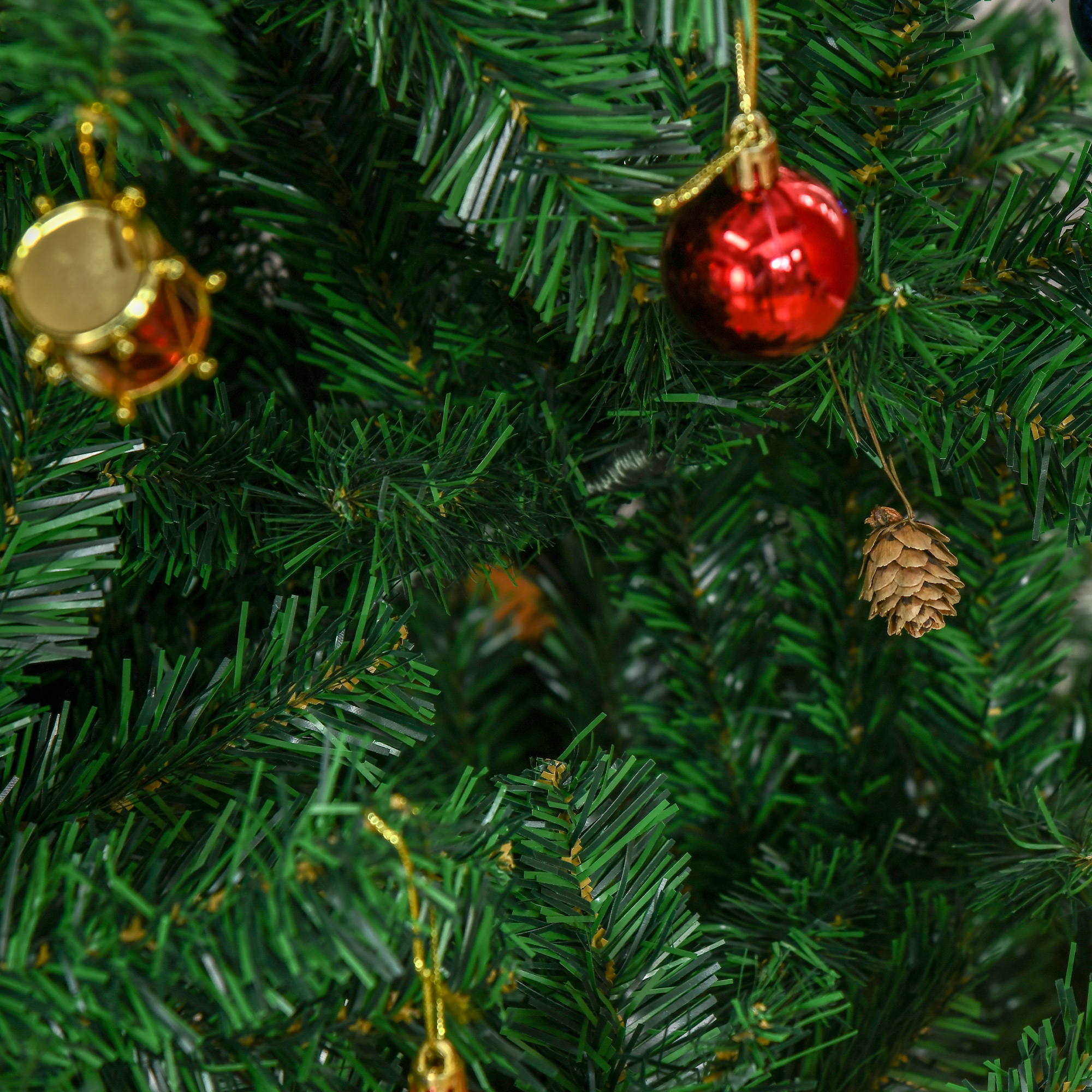 Árbol de Navidad verde con adorno rojo, tambor pequeño y piña.