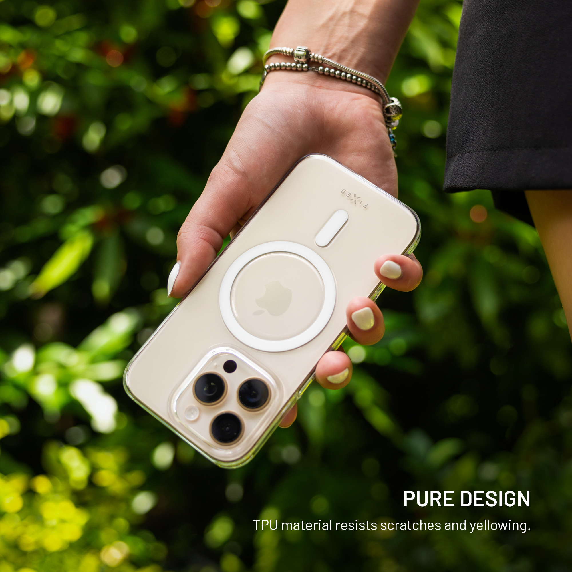 Eine Hand hält ein iPhone in einer transparenten Hülle mit MagSafe-Ring vor grünem Hintergrund.