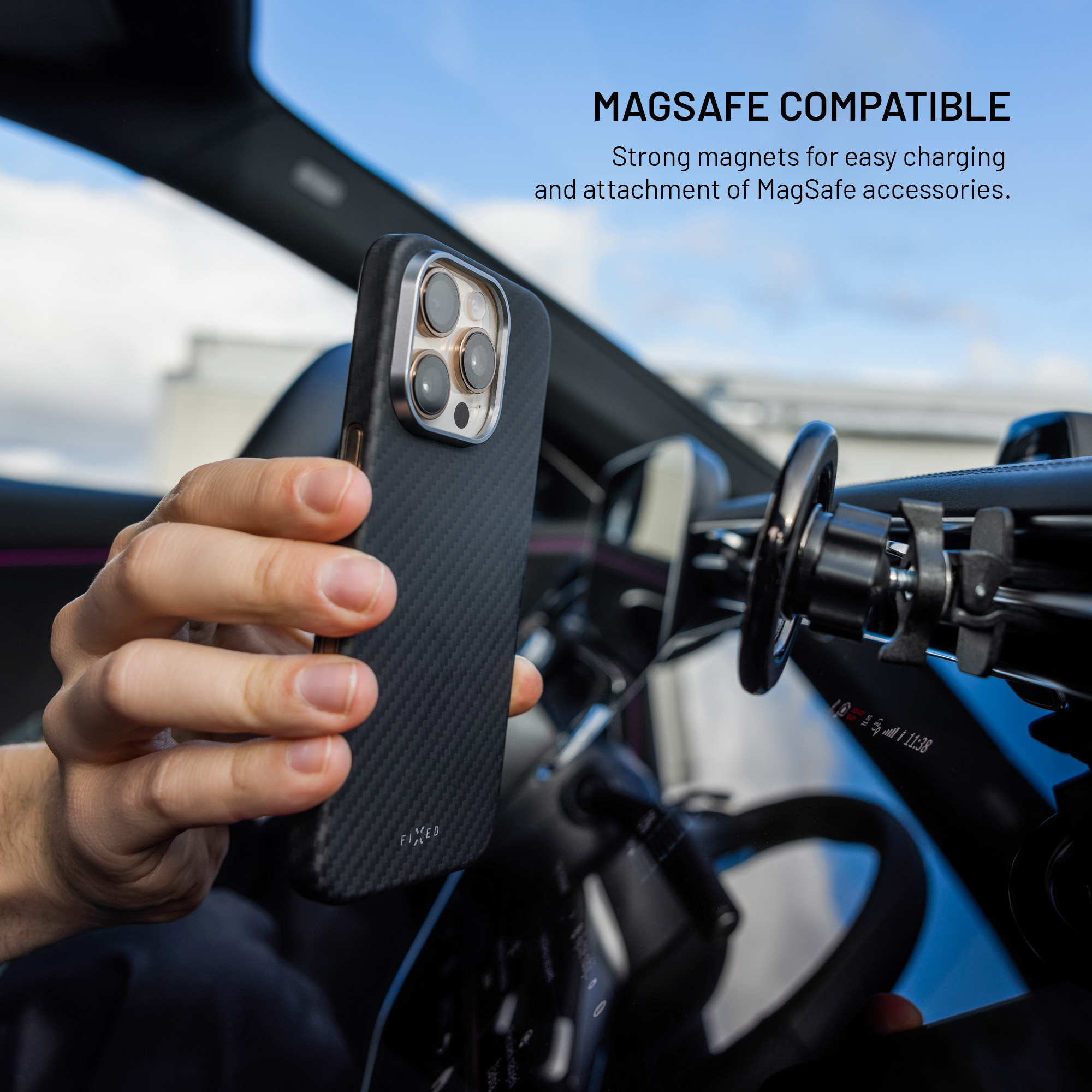 Hand hält ein Smartphone in schwarzer Carbonschutzhülle in einem Auto vor einer Magnethalterung.