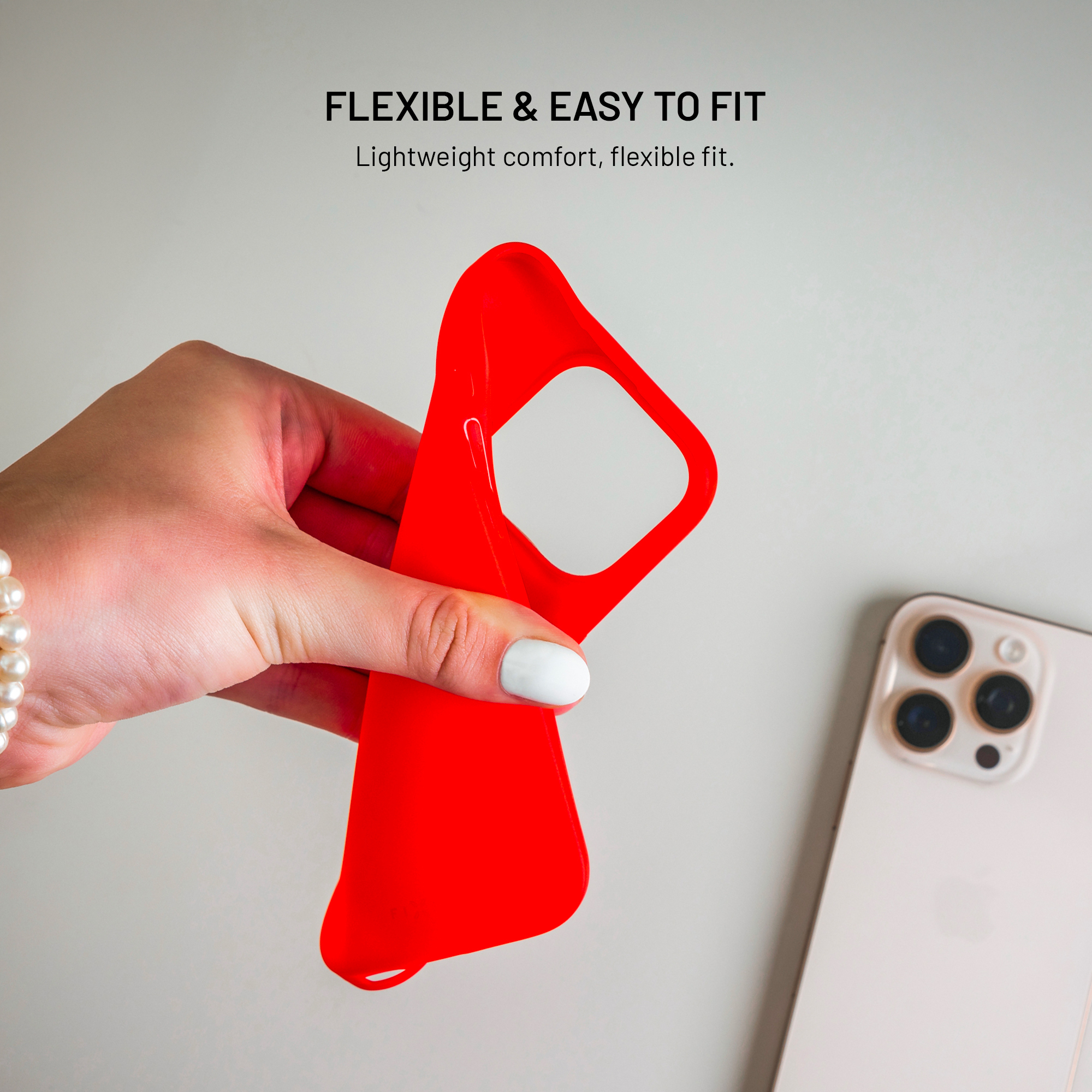 Hand hält eine rote Handyhülle neben einem Smartphone.