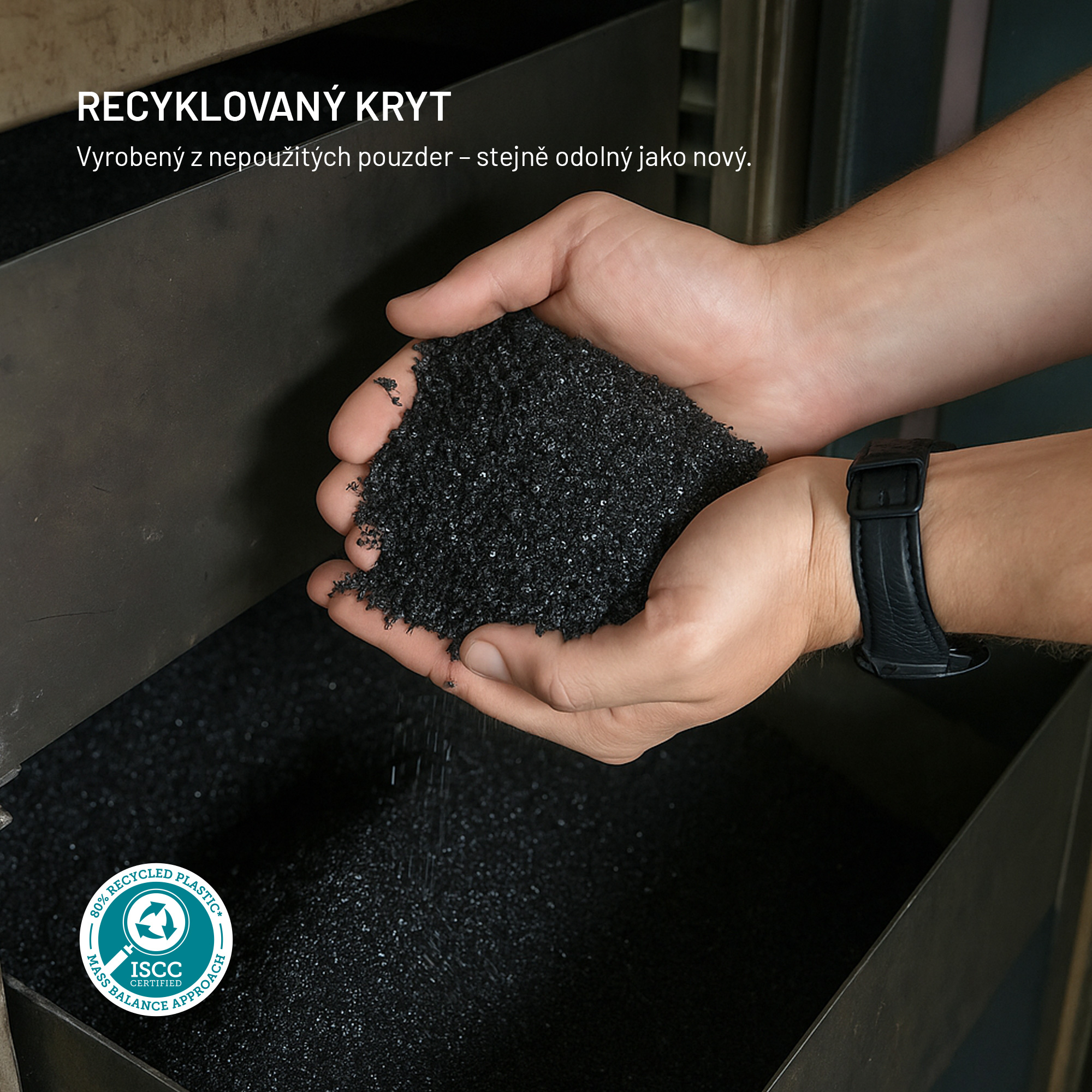 Hände halten schwarzes recyceltes Plastikgranulat über einen Behälter.