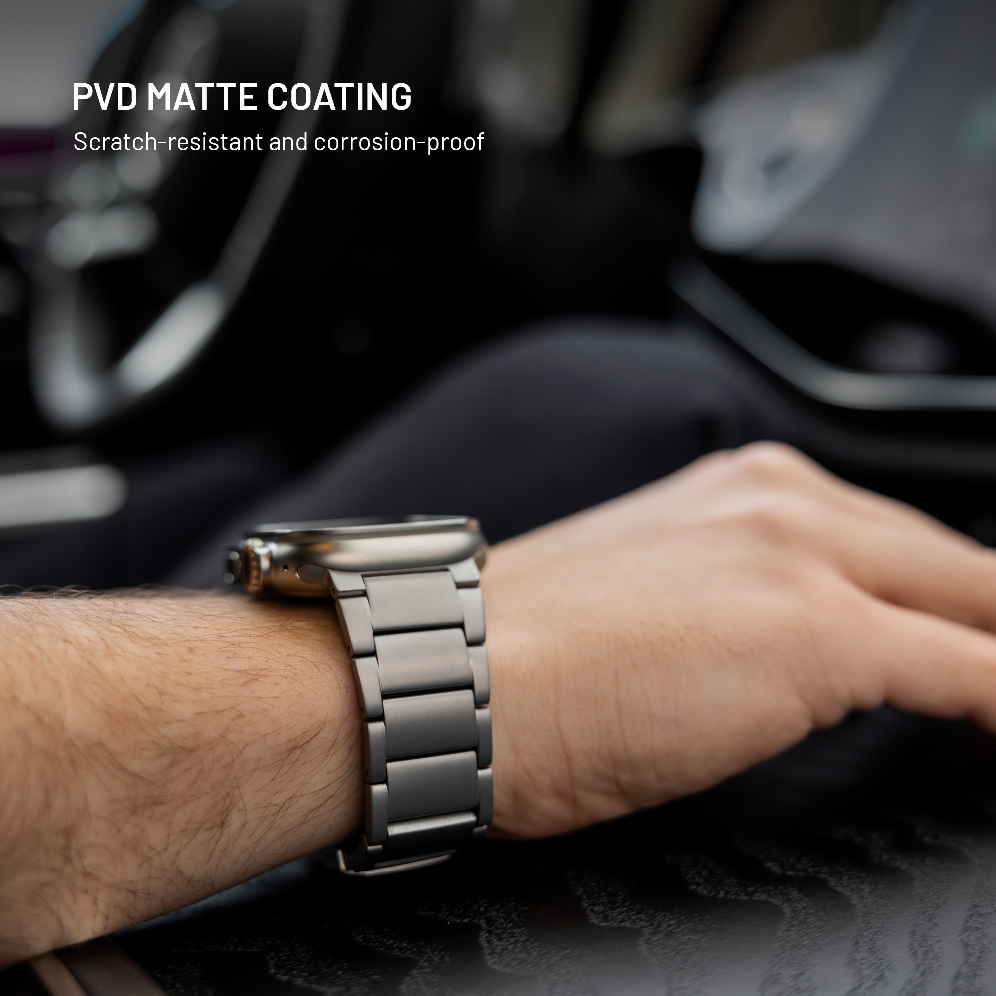 Eine Hand trägt eine Armbanduhr mit matten PVD-Beschichtungs-Metallarmband in einem Auto.