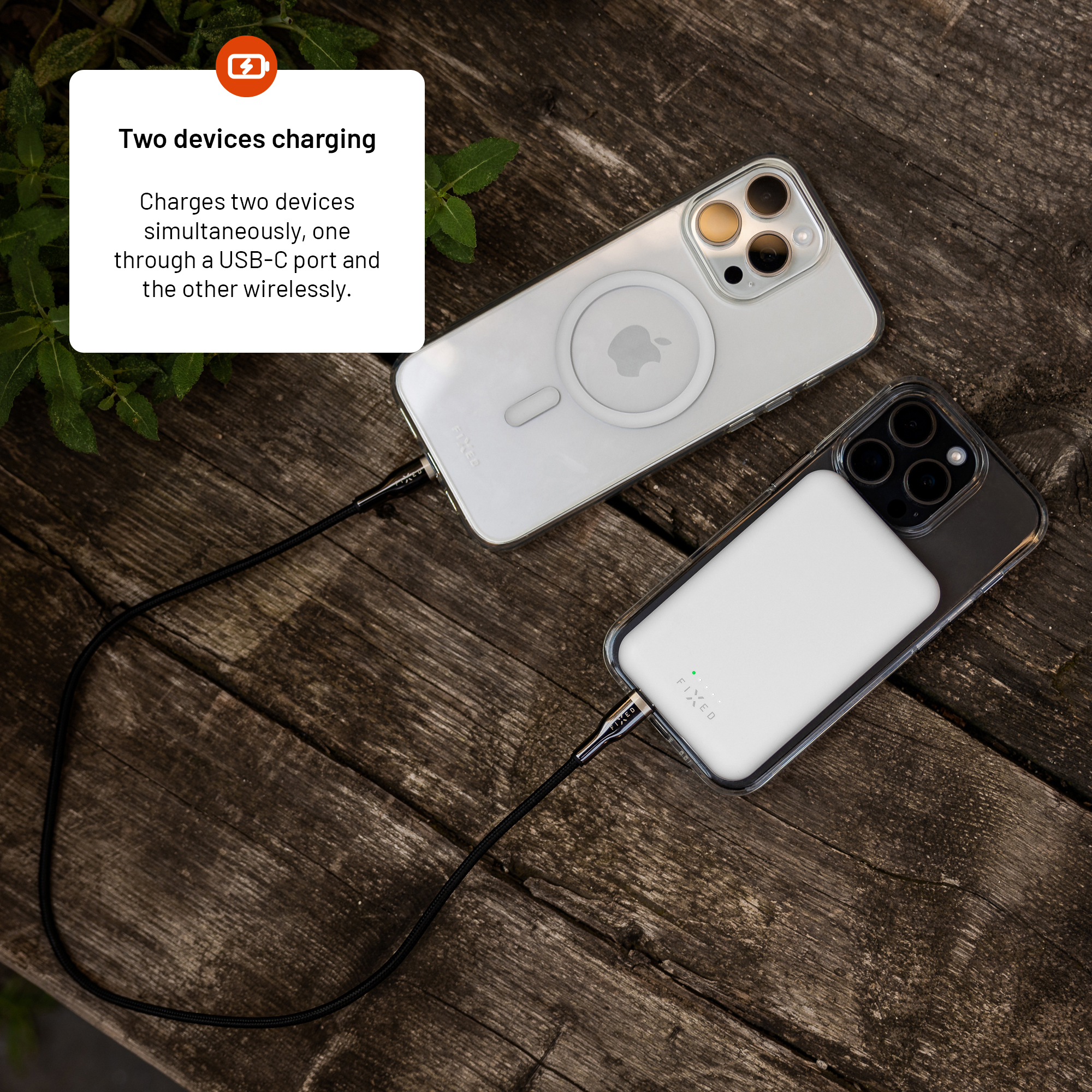 Zwei Smartphones auf Holz laden gleichzeitig über USB-C-Kabel und kabelloses MagSafe.