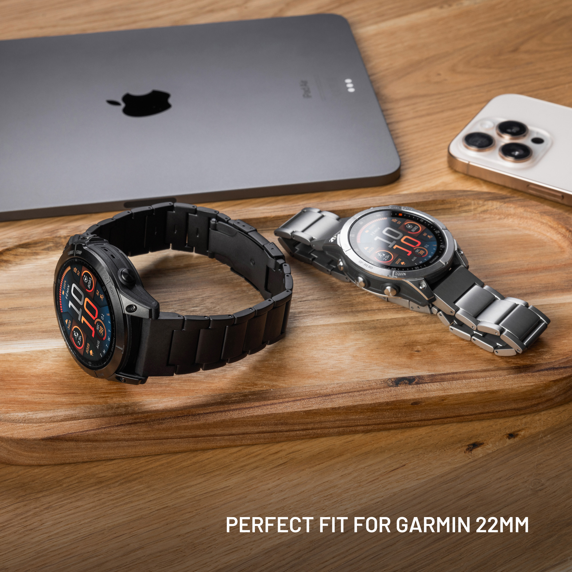 Zwei Smartwatches mit Metallarmbändern liegen auf einem Holztablett neben Tablet und Smartphone.