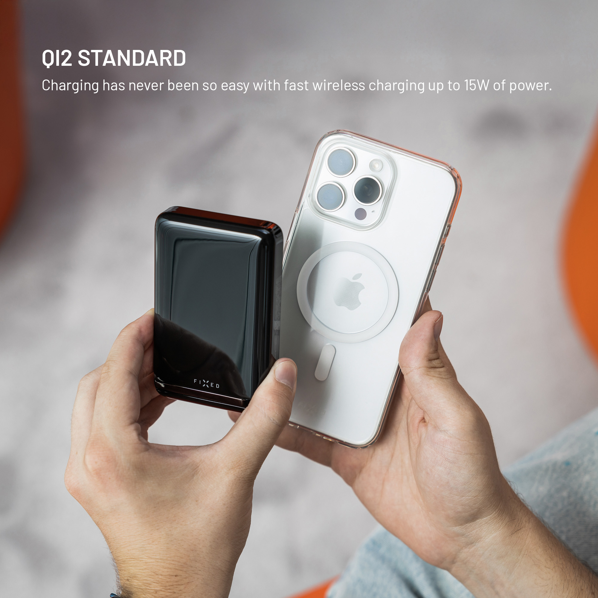 Hände halten eine schwarze Powerbank neben einem iPhone mit MagSafe. Text lautet Qi2 Standard.