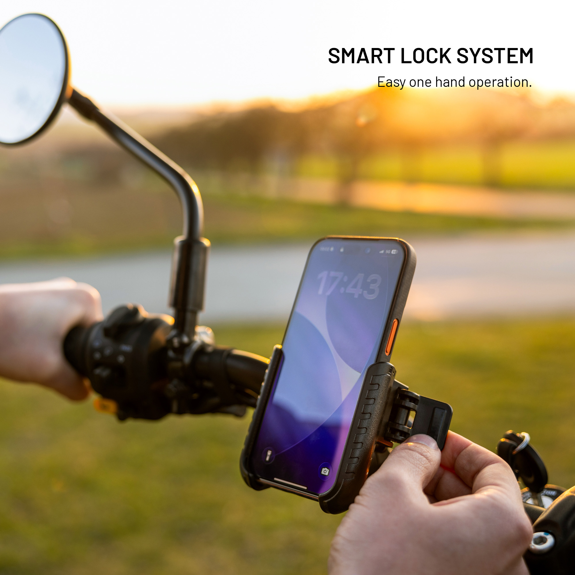 Ein Smartphone ist sicher in einer Halterung am Motorradlenker befestigt, während eine Hand das Schlosssystem bedient.