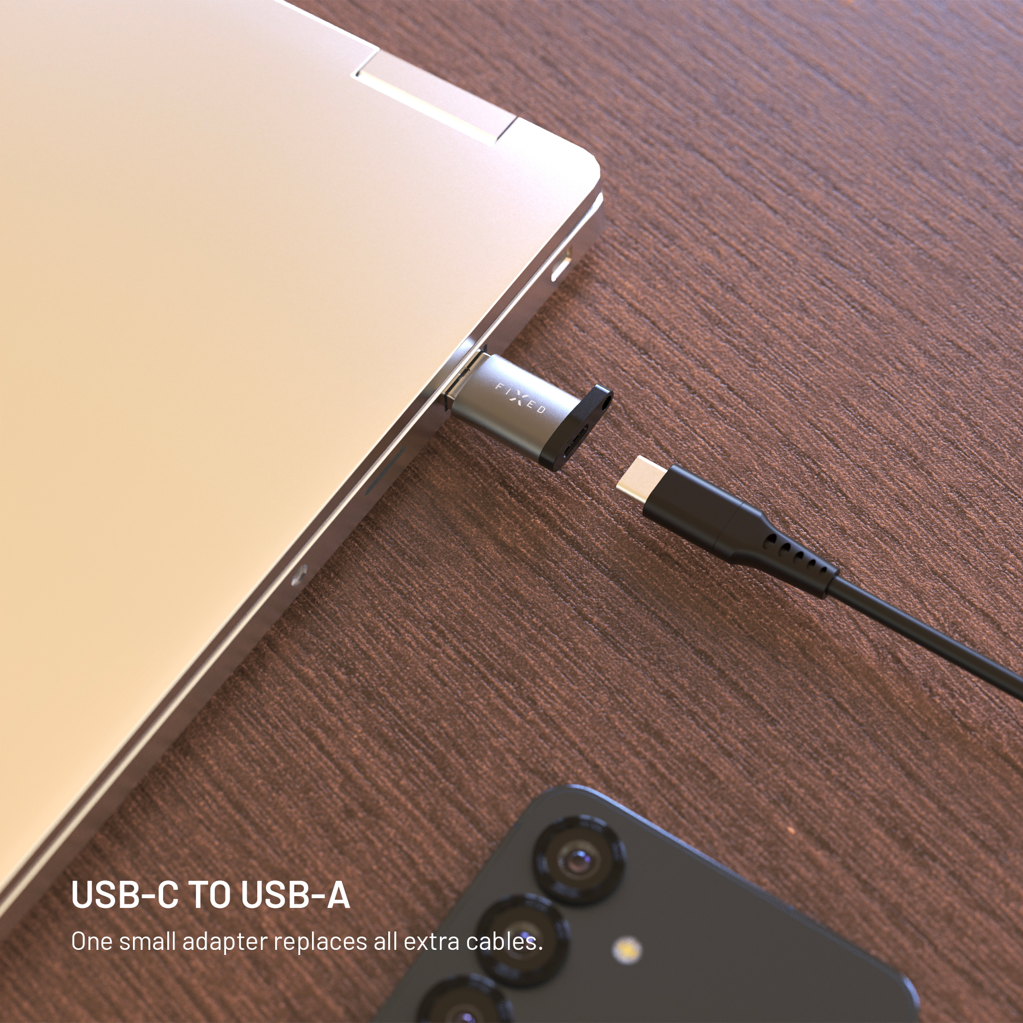 Ein USB-C-Adapter steckt in einem Laptop, bereit für ein Kabel, mit einem Smartphone auf hölzernem Tisch.