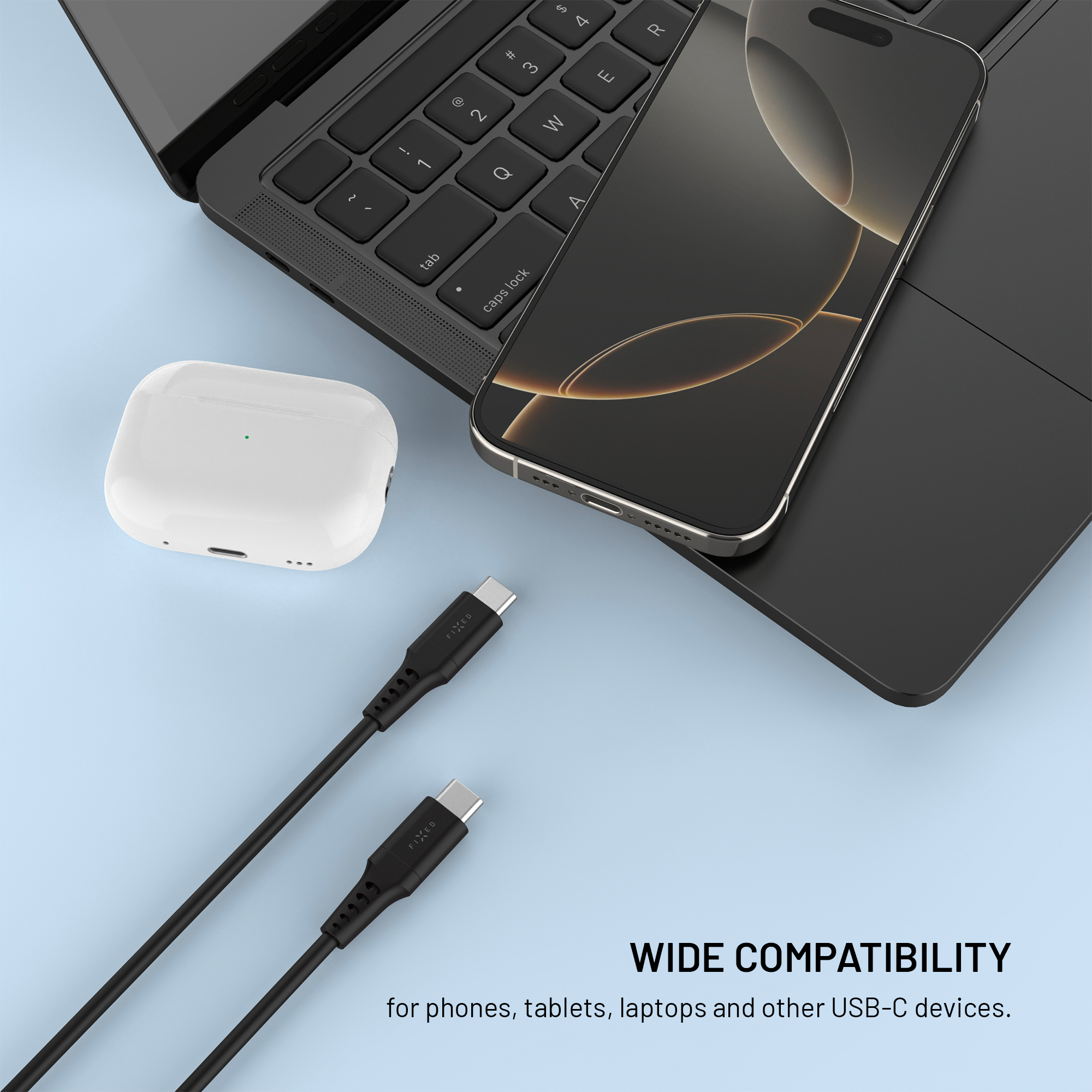 Ein Smartphone, kabellose Ohrhörer und zwei schwarze USB-C-Kabel liegen vor hellblauem Hintergrund auf einem Laptop.