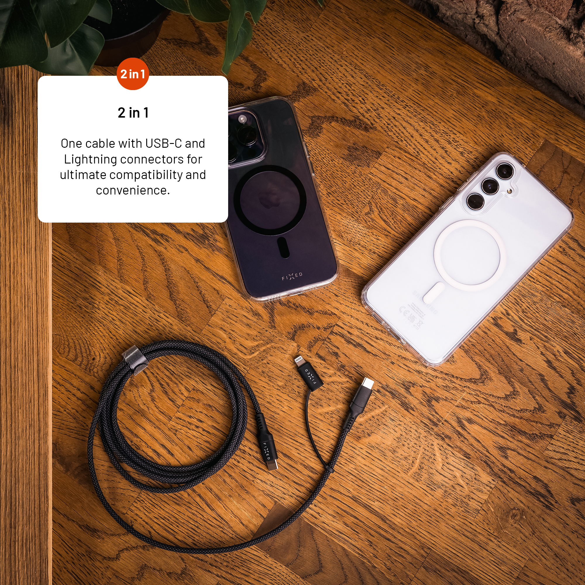 Ein geflochtenes Ladekabel mit USB-C und Lightning sowie zwei Smartphones in Schutzhüllen auf Holz.