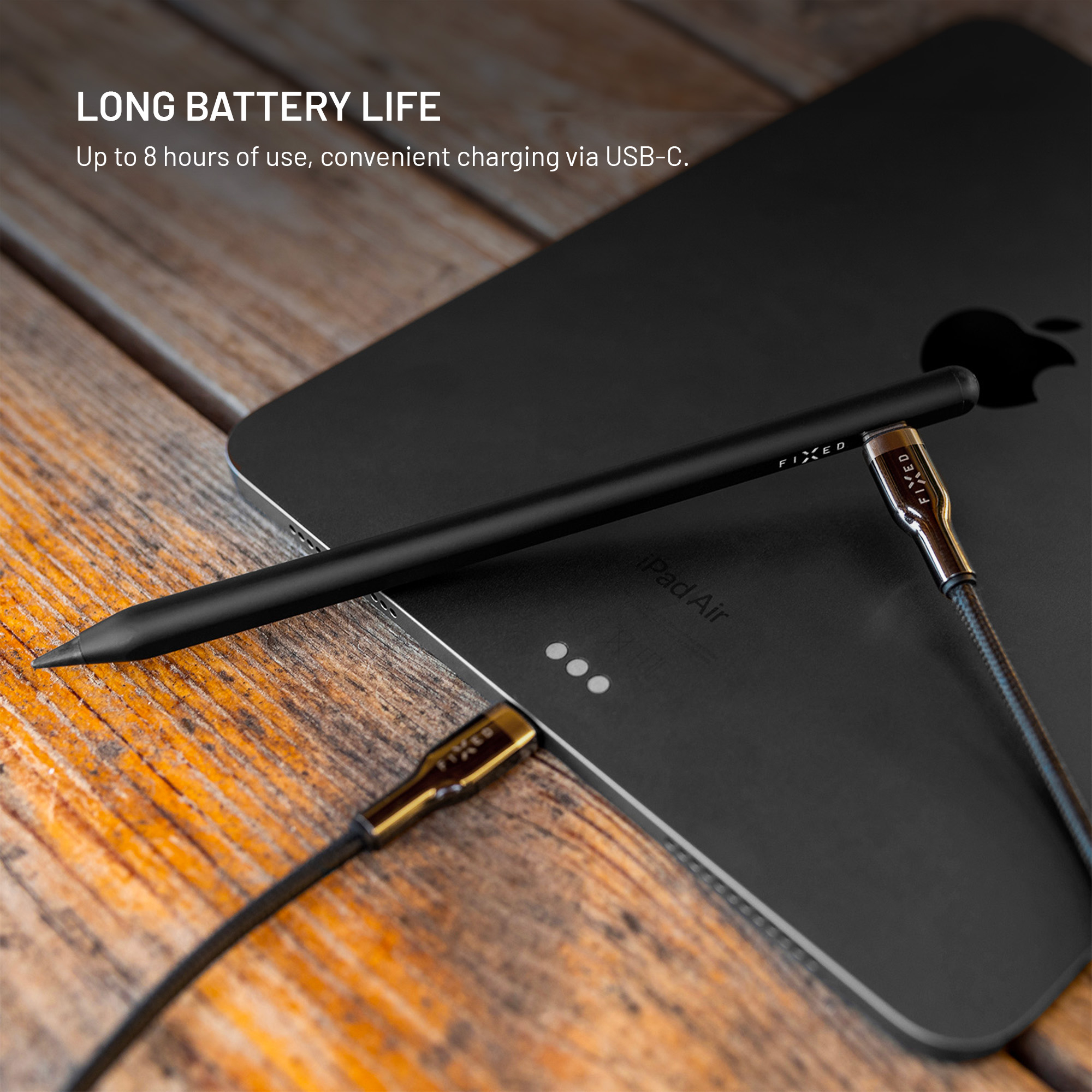 Ein schwarzer Stift liegt auf einem schwarzen Tablet auf Holz, mit Text LONG BATTERY LIFE.