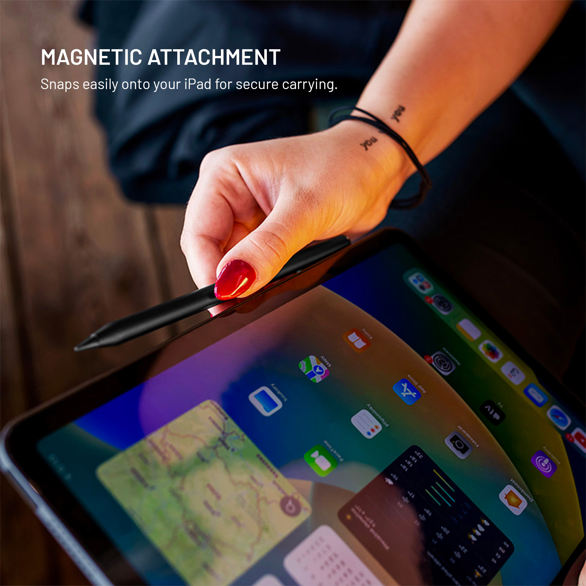 Eine Hand hält einen schwarzen Stift nahe eines iPads, der Text lautet: Magnetic Attachment.
