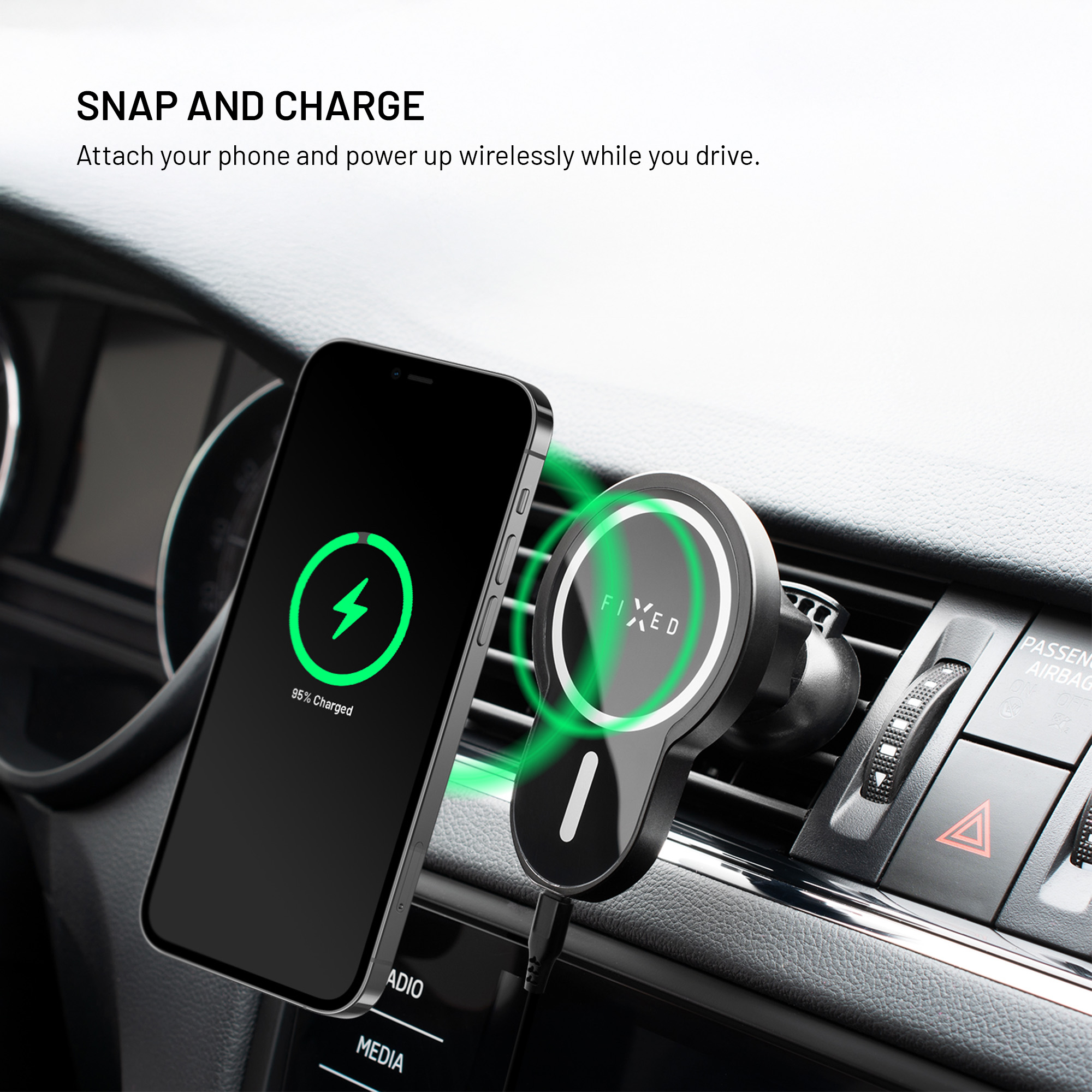 Ein Smartphone hängt an einer magnetischen Halterung am Lüftungsgitter eines Autos und wird kabellos geladen.