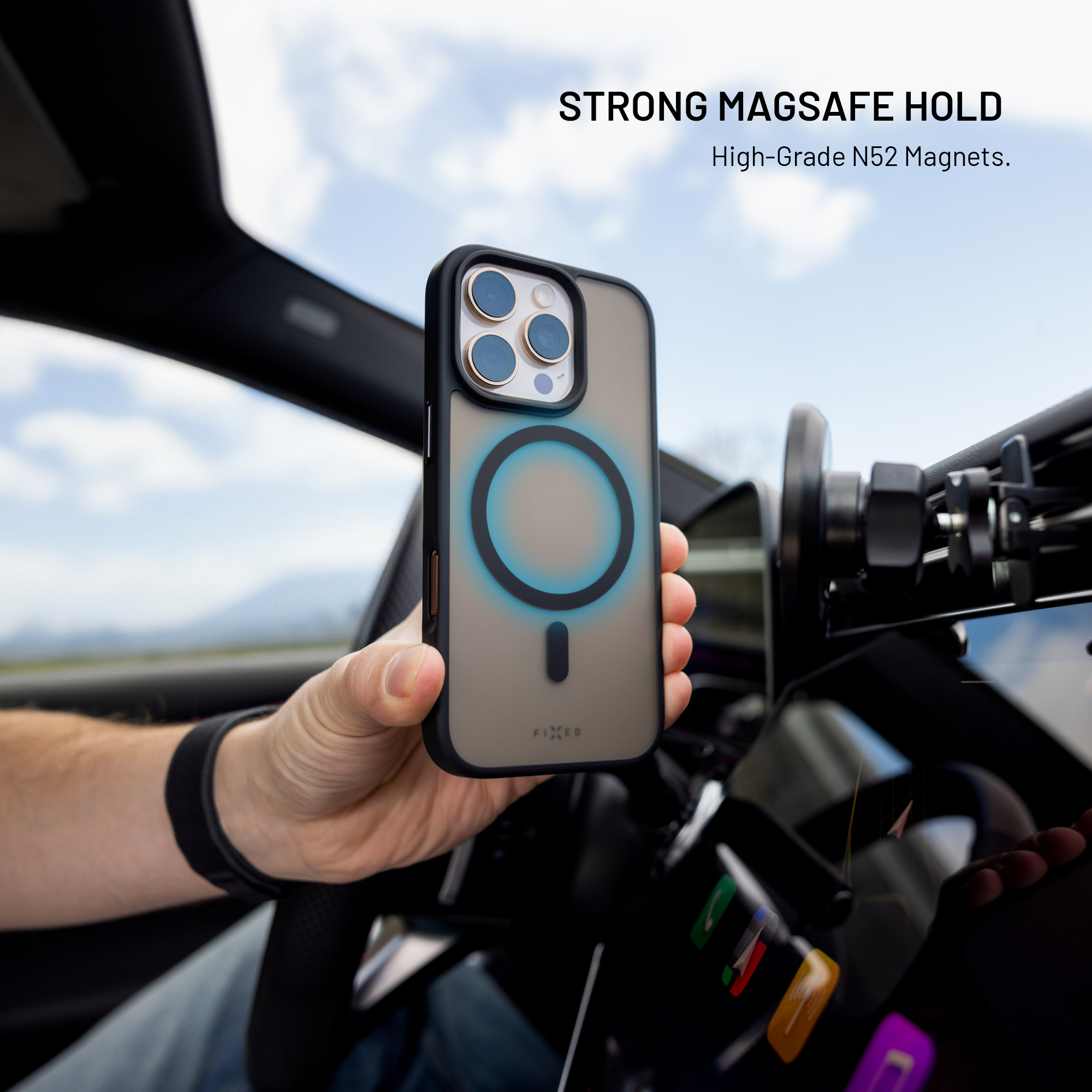 Hand hält iPhone mit MagSafe-Hülle in einem Autoinnenraum.