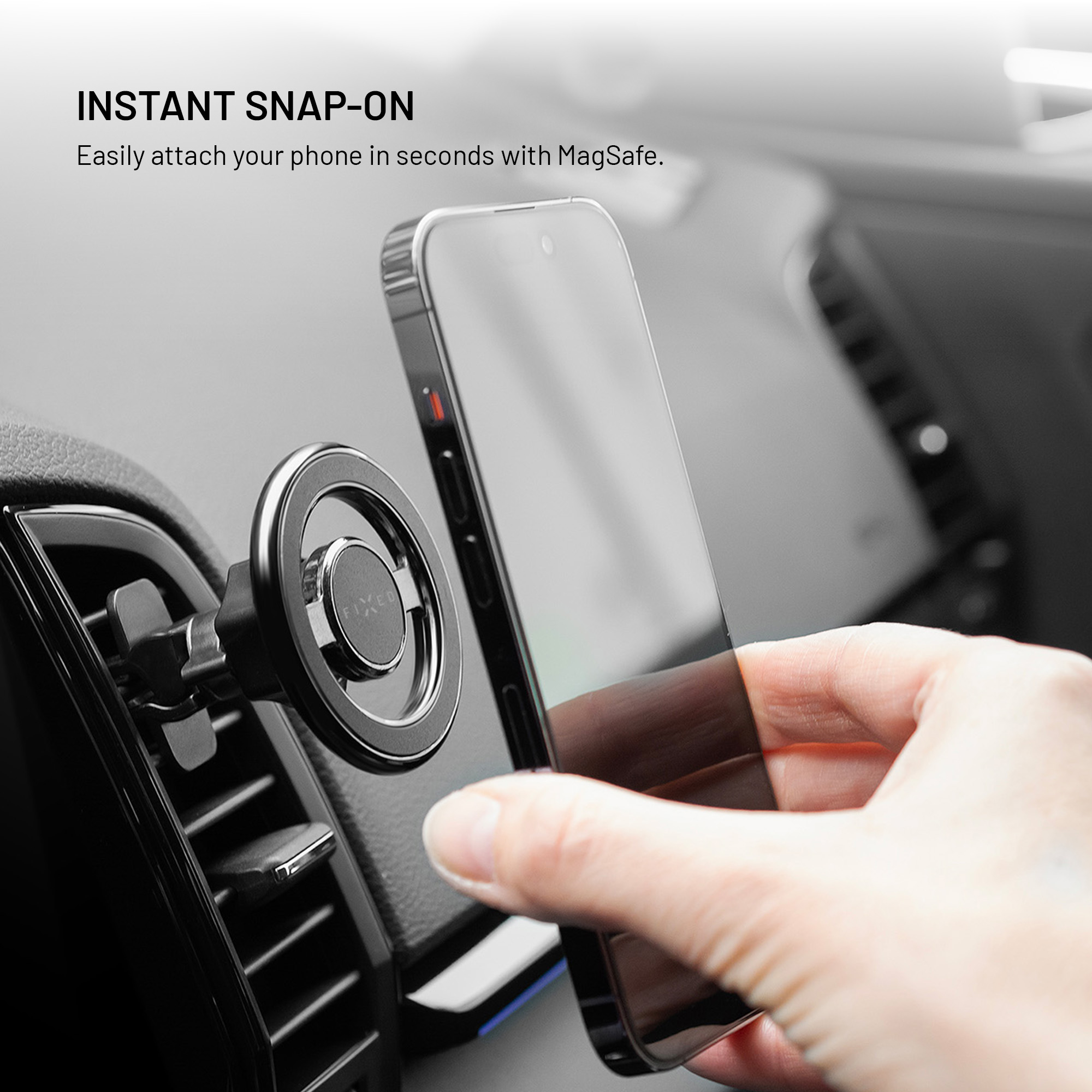 Hand befestigt Smartphone an einer magnetischen Autohalterung im Lüftungsgitter.