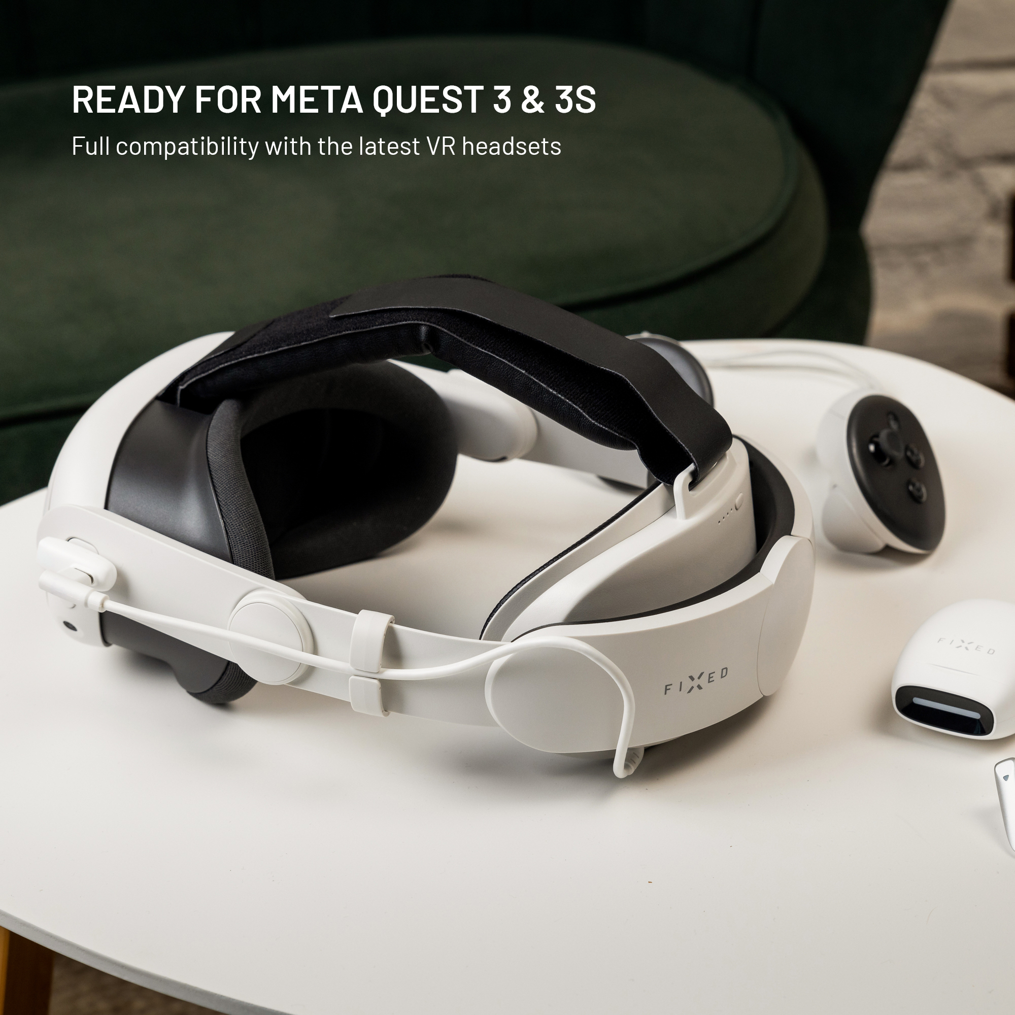Ein weißer VR-Headset-Gurt mit Zubehör liegt auf einem weißen Tisch vor einem grünen Sessel.