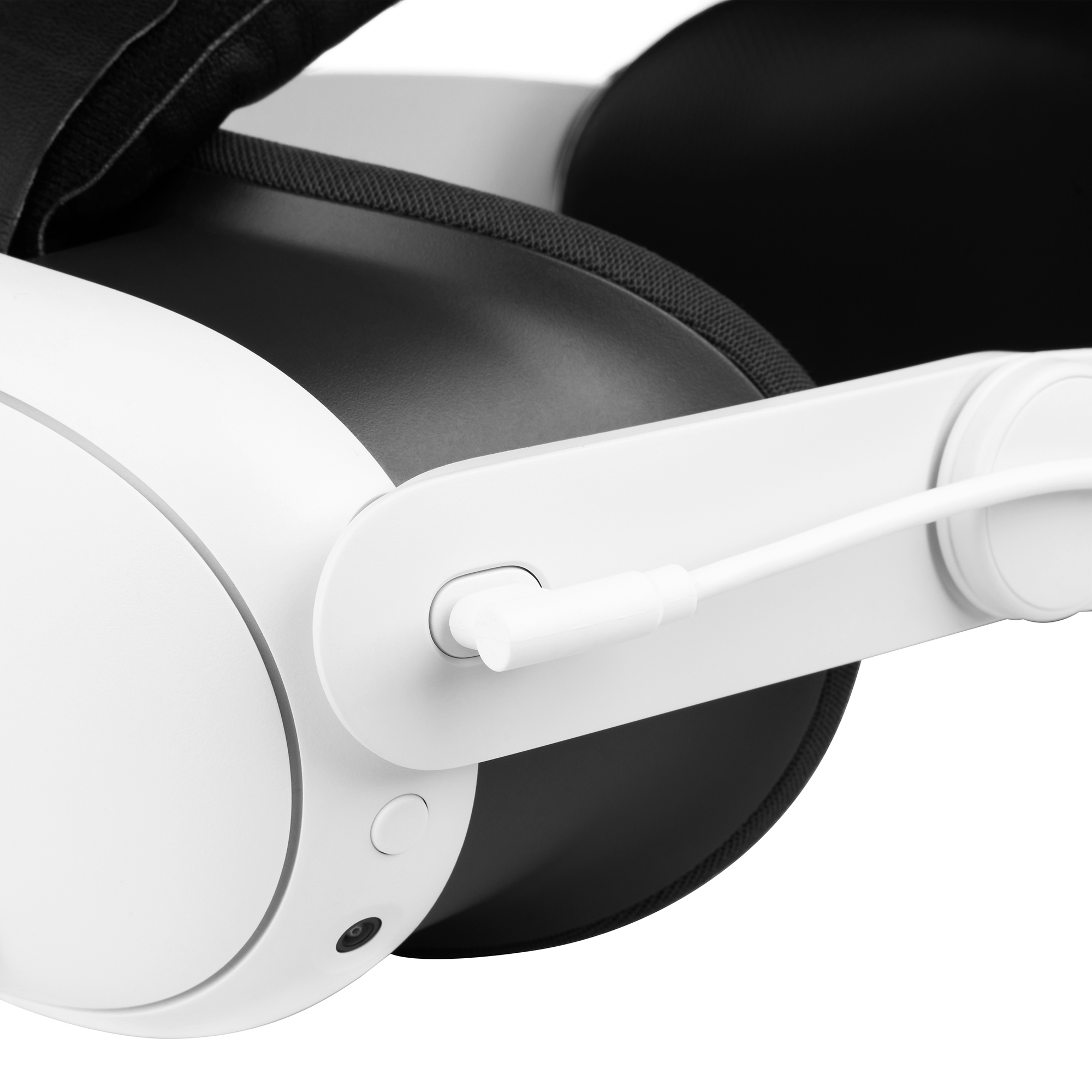 Nahaufnahme eines weiß-schwarzen VR-Headsets mit angeschlossenem Kabel am Seitenriemen vor weißem Hintergrund.