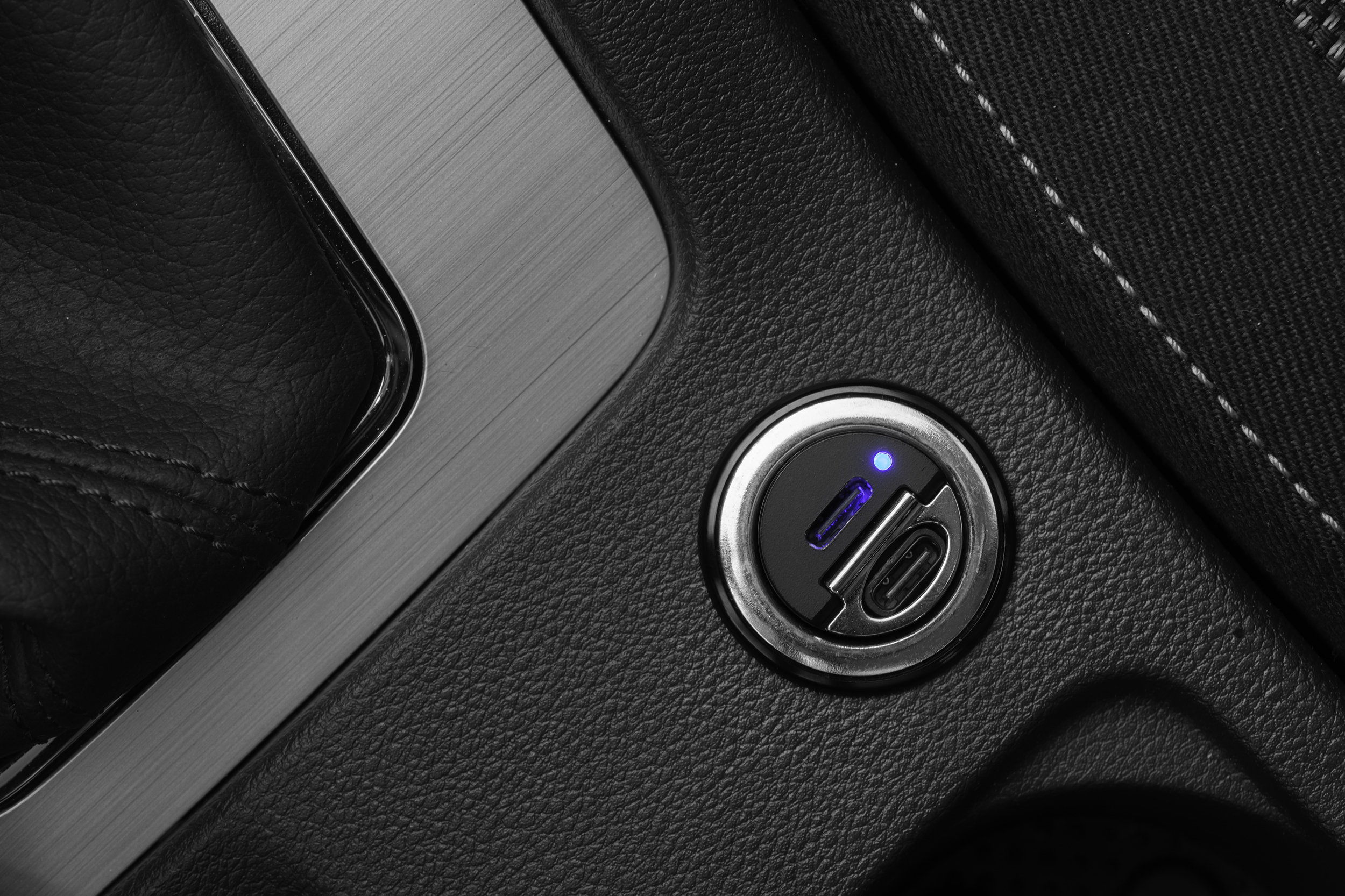 Ein Dual-USB-Autoladegerät mit blauer LED-Anzeige in der Mittelkonsole.