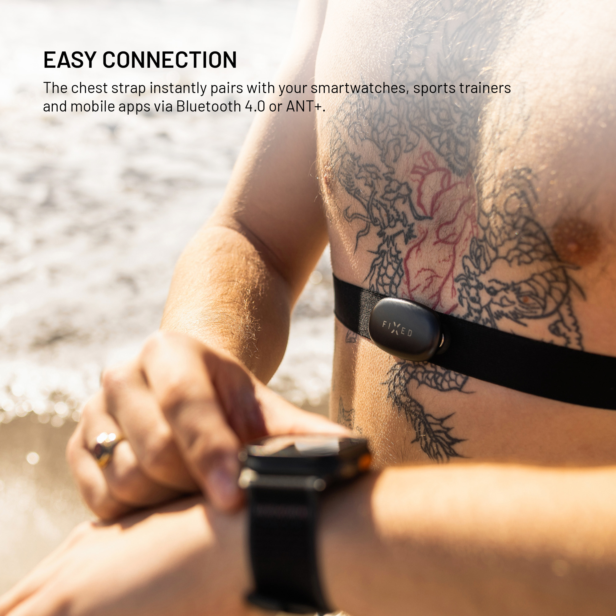 Eine Person mit Brustgurt und Smartwatch draußen am Meer.