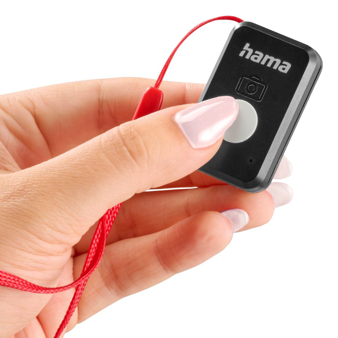 Una mano tiene un telecomando Hama nero con un pulsante bianco e un laccetto rosso.