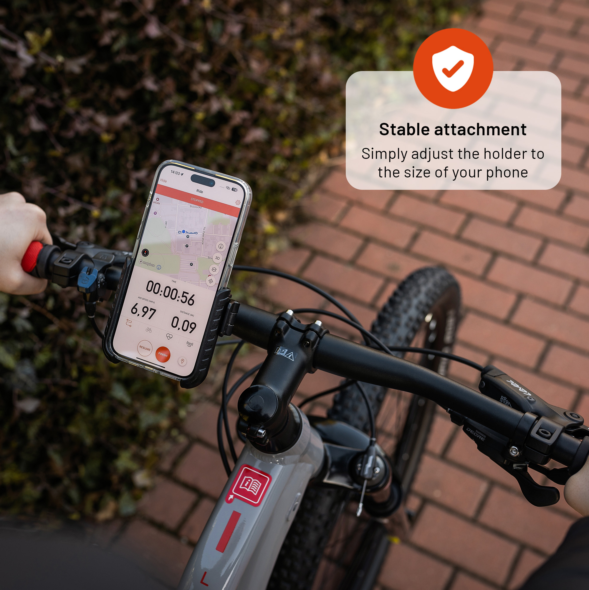 Smartphone in Halterung an Fahrradlenker mit Text.
