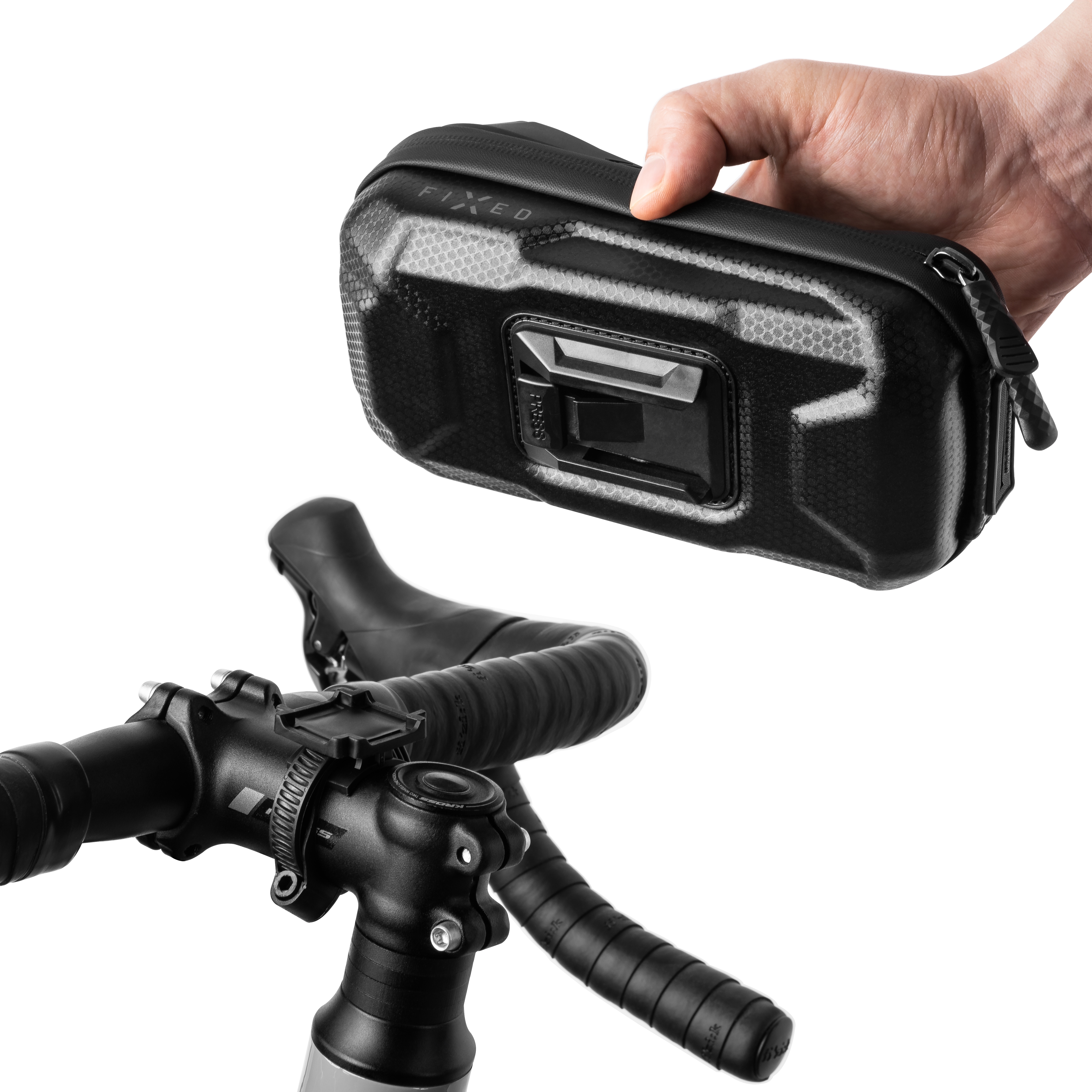 Eine Hand hält eine schwarze FIXD-Fahrradtasche mit Halterung über einem Fahrradlenker auf weißem Hintergrund.