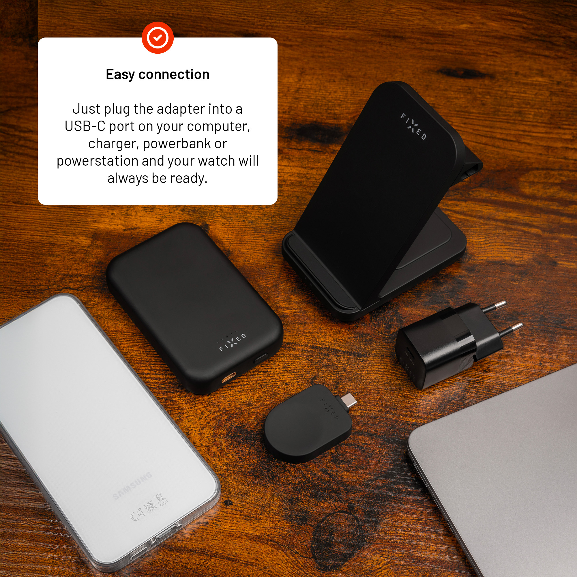 Schwarze Tech-Accessoires inklusive kabellosem Ladegerät, Powerbank und Adapter auf Holzoberfläche.