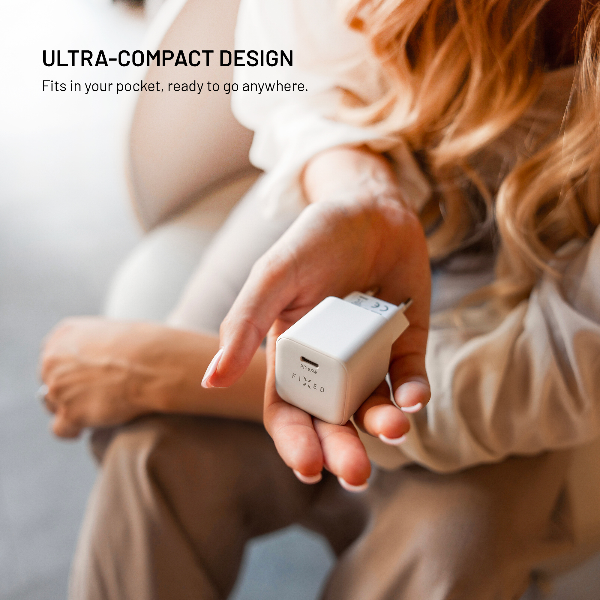 Eine Frau hält ein kleines weißes USB-C-Ladegerät in ihrer Hand.