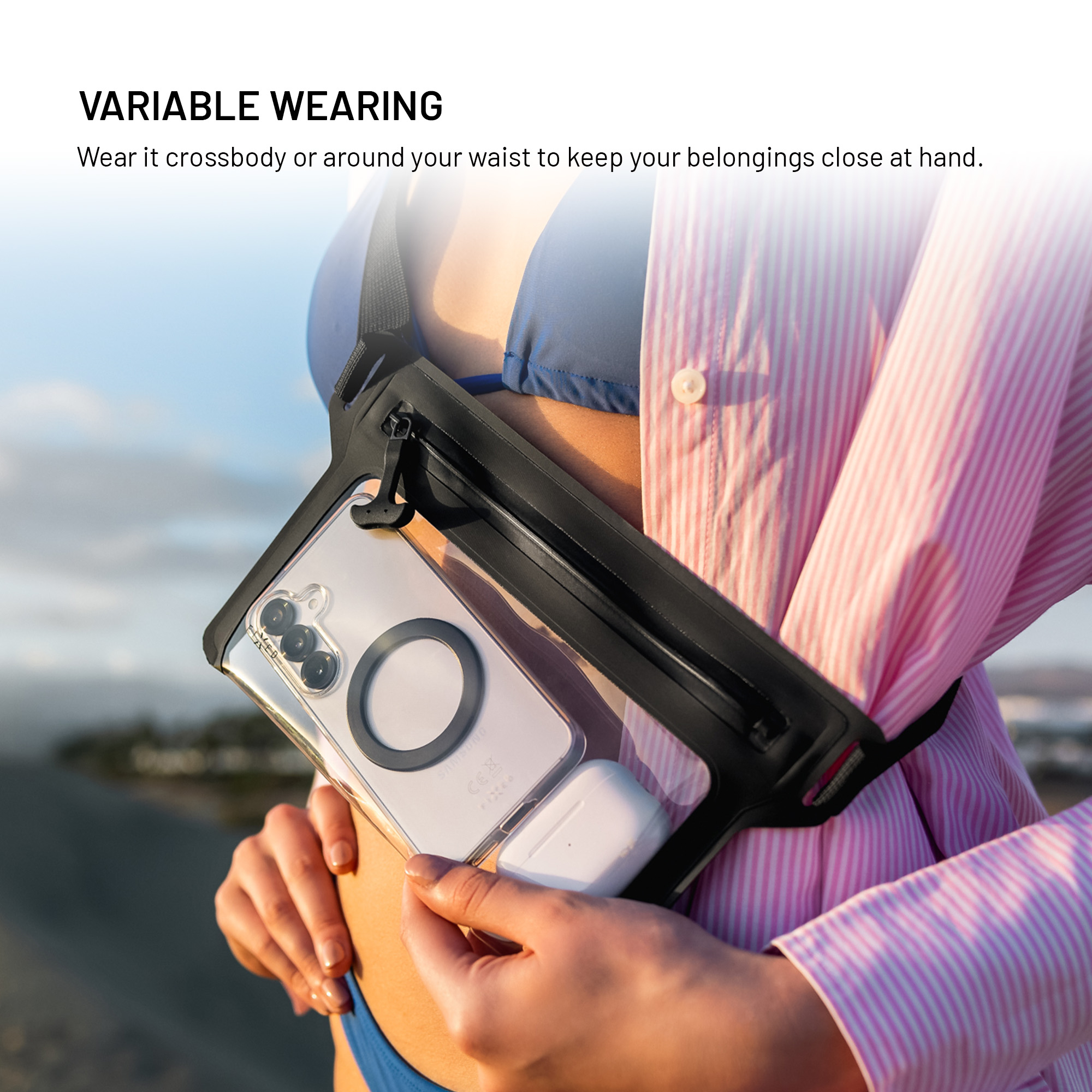Person trägt wasserdichte Tasche mit Smartphone quer über der Brust, am Strand.