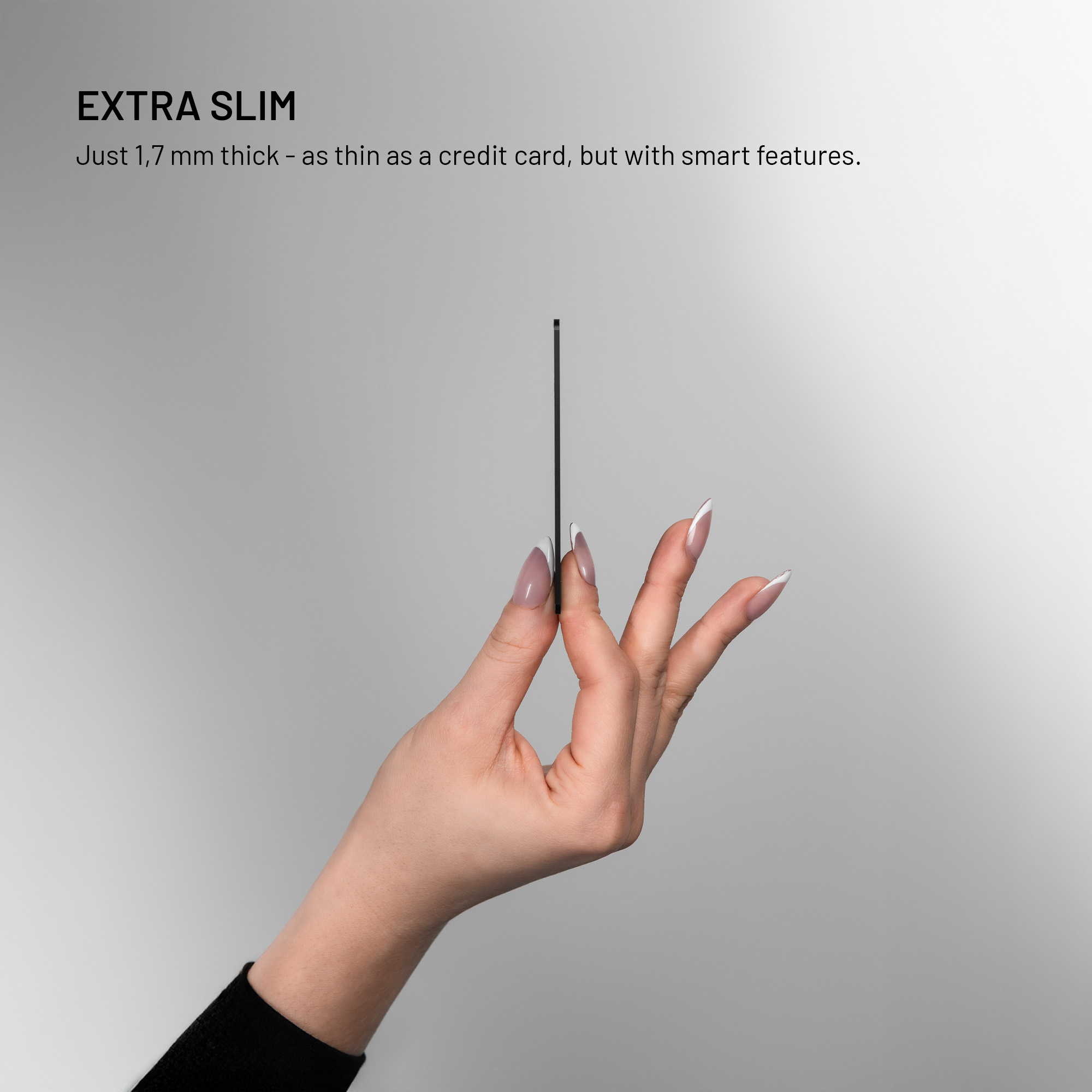 Eine Hand hält eine extrem dünne schwarze Karte vor einem hellgrauen Hintergrund.