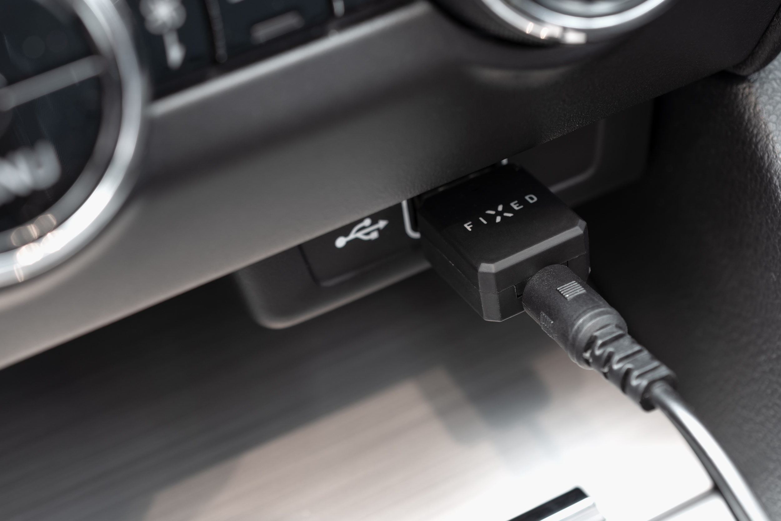 Ein schwarzer Fixed-USB-Adapter mit einem angeschlossenen Kabel in einem Auto.